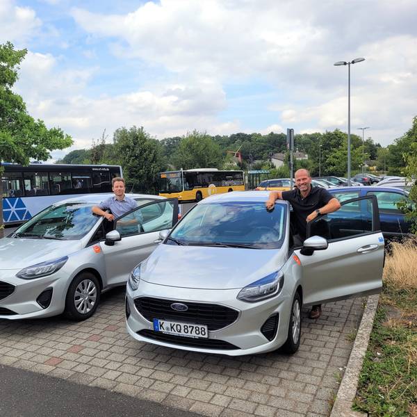 Auf dem Foto sind Laurenz Miehe (Cambio Rheinland) und Markus Auel (Gemeinde Kall) jeweils neben einem Ford Fiesta zu sehen.