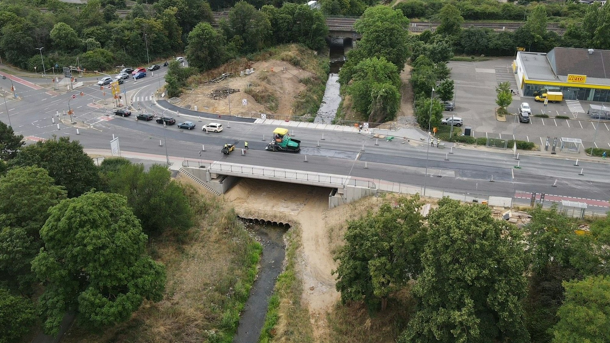 Das Luftbild zeigt die Erftbrücke. Auf der Brücke wird gerade die Fahrbahn asphaltiert.