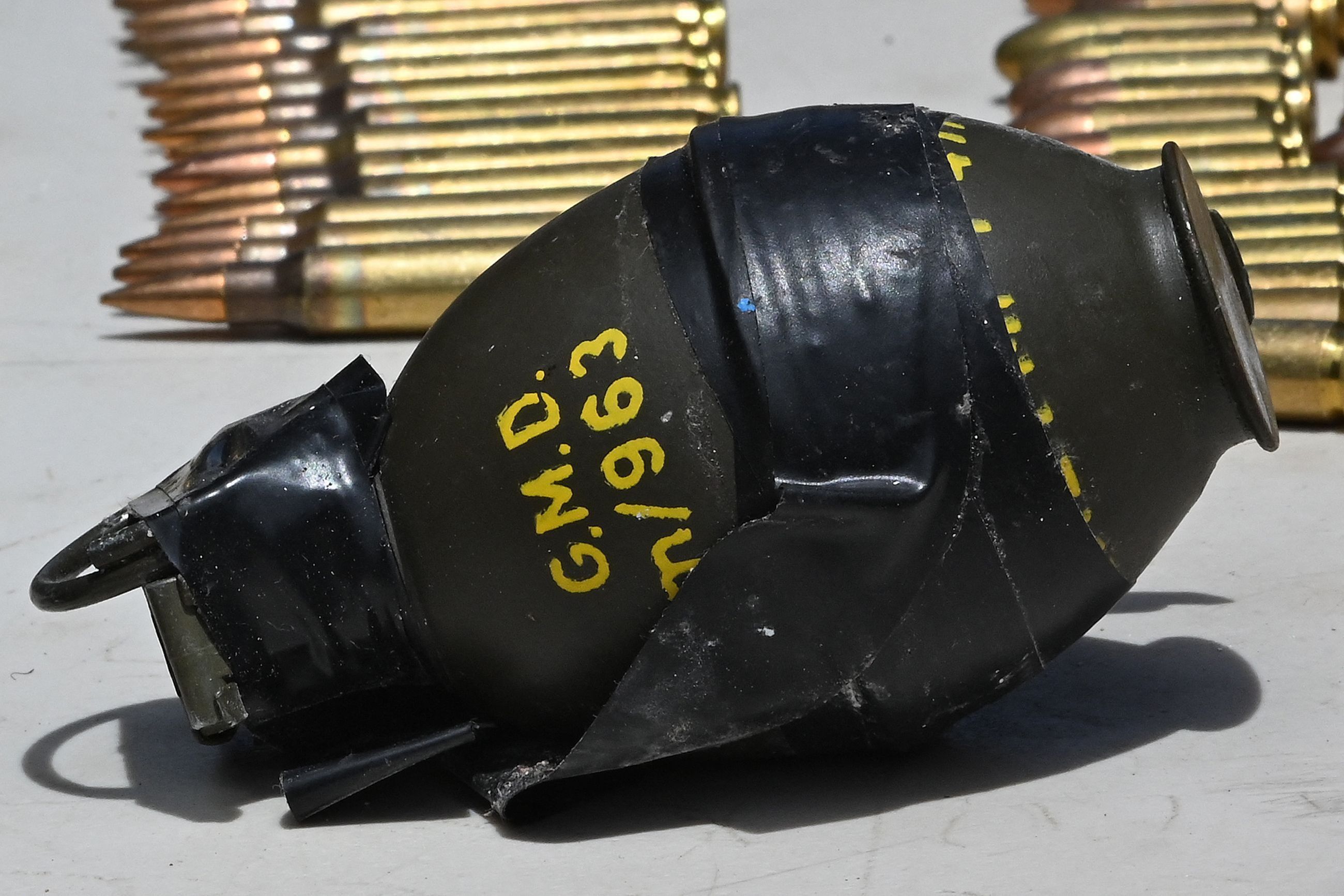 Eine Handgranate liegt vor Schussmunition.