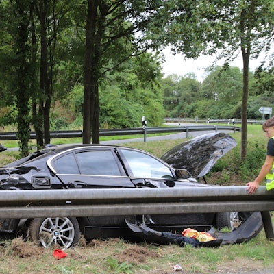 Ein schwer beschädigtes Auto steht neben einer Leitplanke.