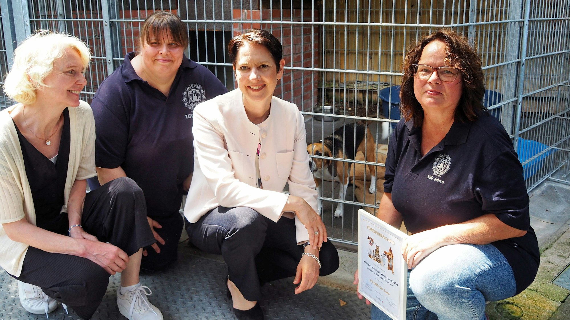 Die Frauen knien mit einem Hund in einer Reihe.