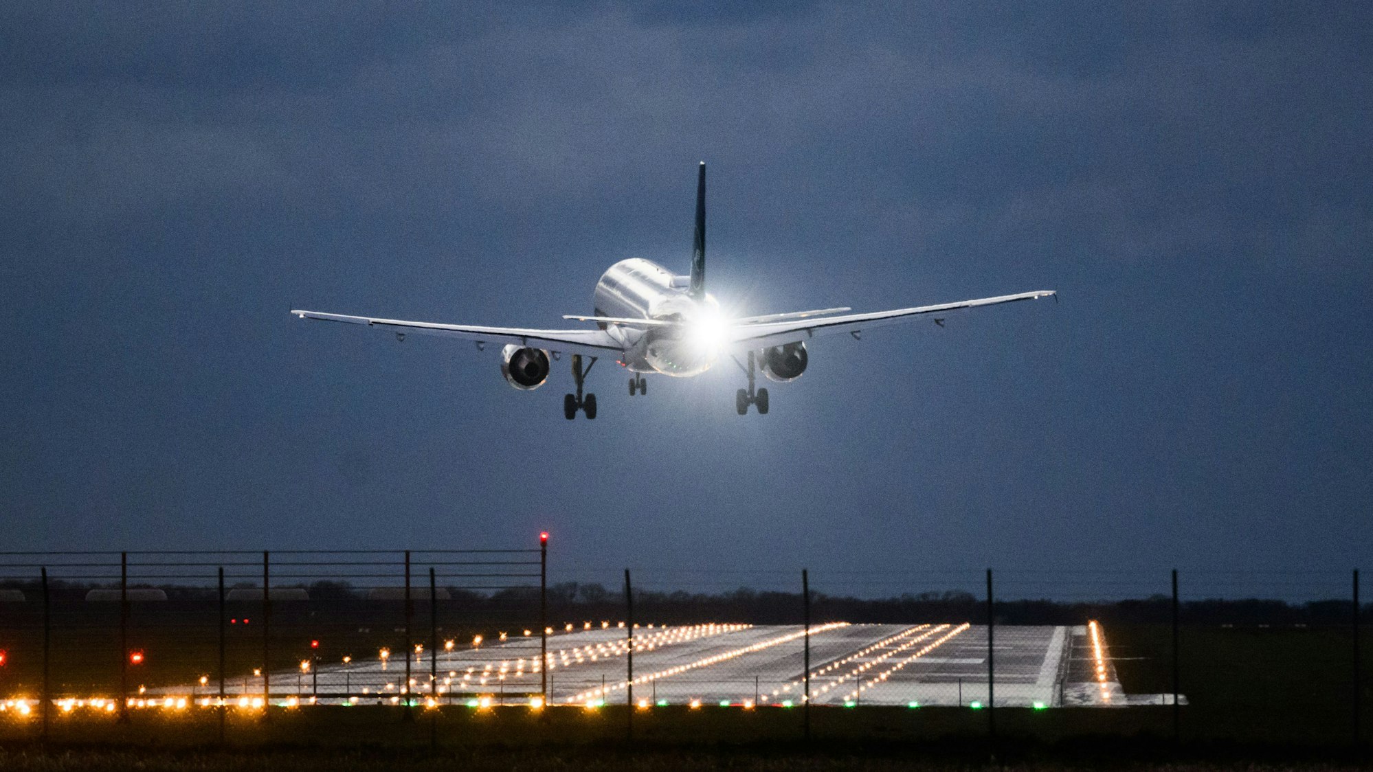 Ein Flugzeug steht kurz vor der Landung aufgrund von Windböen in deutlicher Schräglage in der Luft. (Symbolbild)