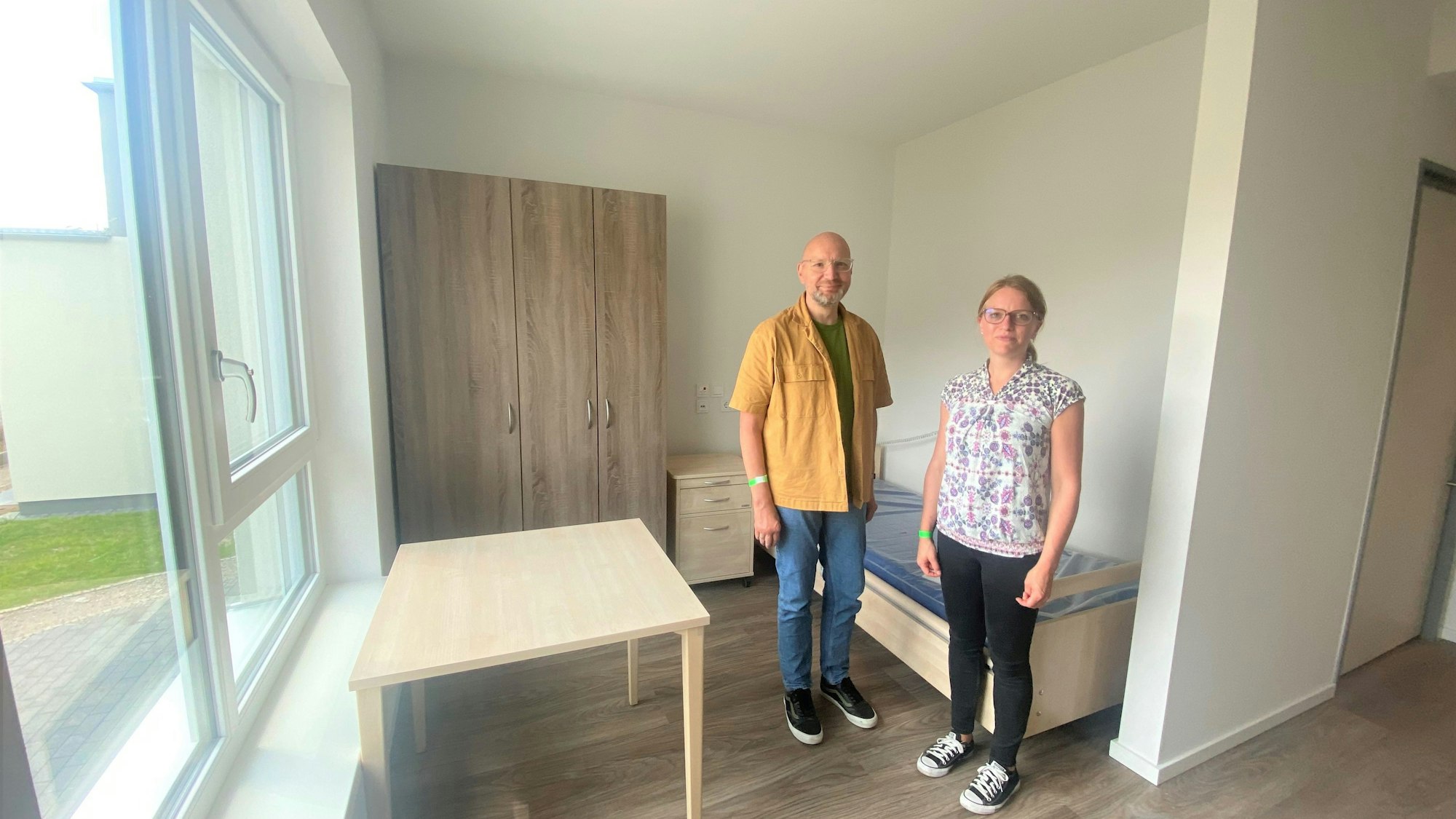 In dem Zimmer steht ein Bett und ein Tisch.