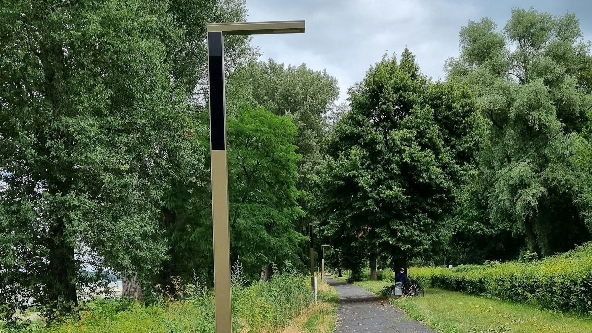 Eine braun-beige Solarleuchte steht am Rand des Weges am Bad Honnefer Rheinufer.