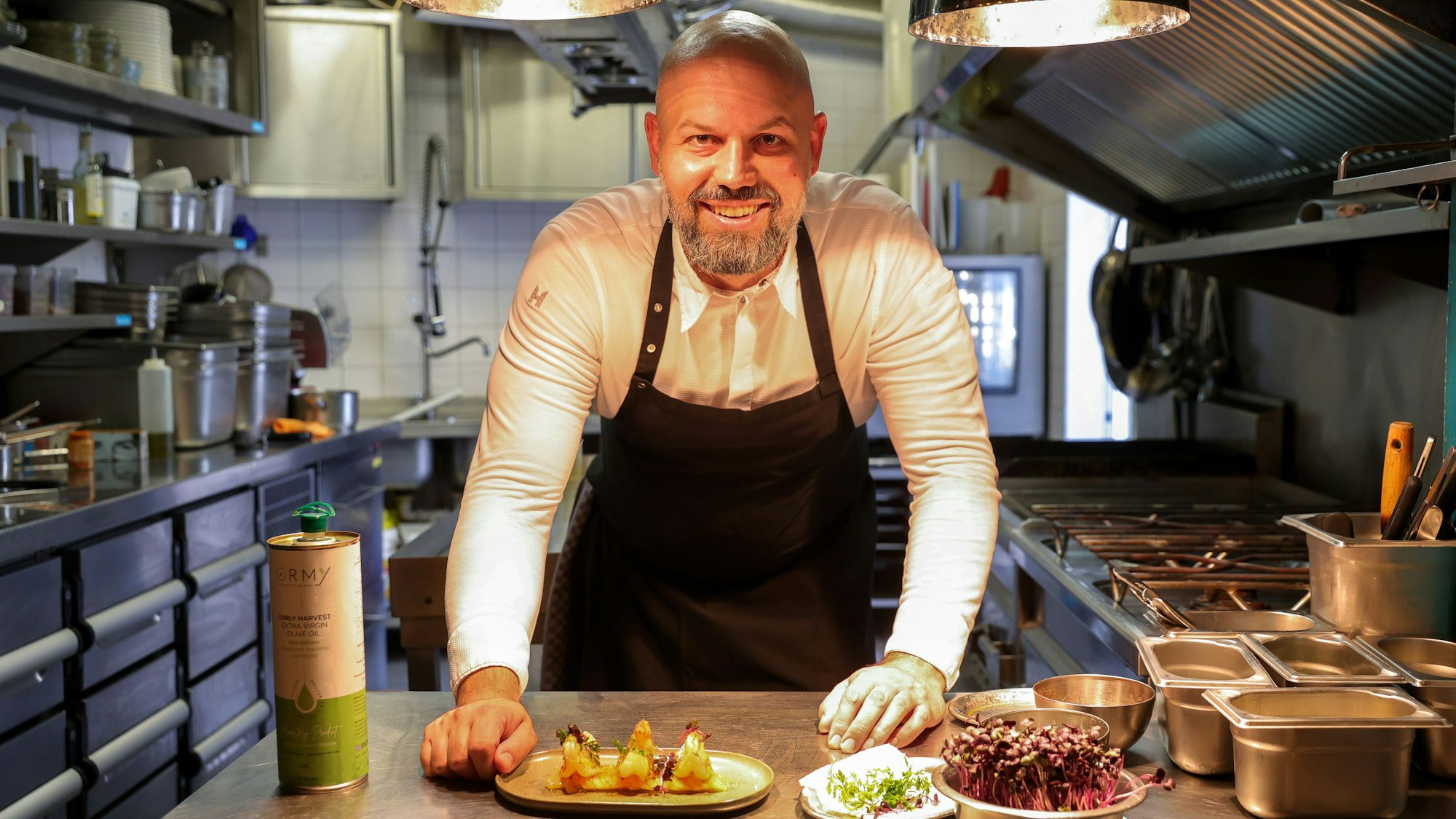Der Koch Konstantin Tzikas in der Küche seines Restaurants Phaedra mit einem zuebreiteten Gericht.
