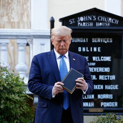 Der frühere US-amerikanische Präsident Donald Trump schaut auf ein Buch, das er in den Händen hält. (Archivbild)