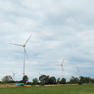 Das Bild zeigt sieben Windräder eines Windparks in der Eifel.