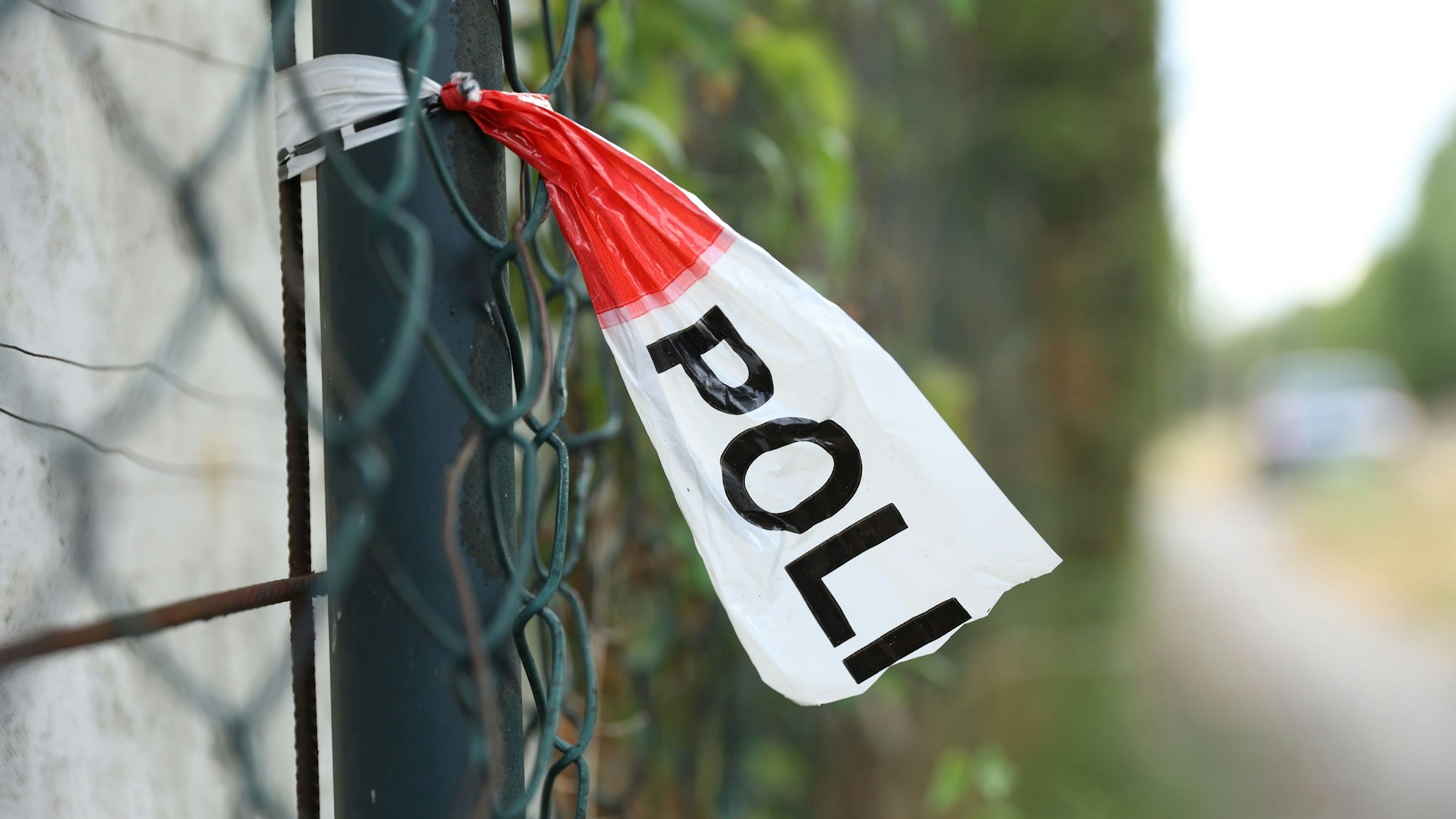 Ein Polizeiabsperrband an einem Zaun