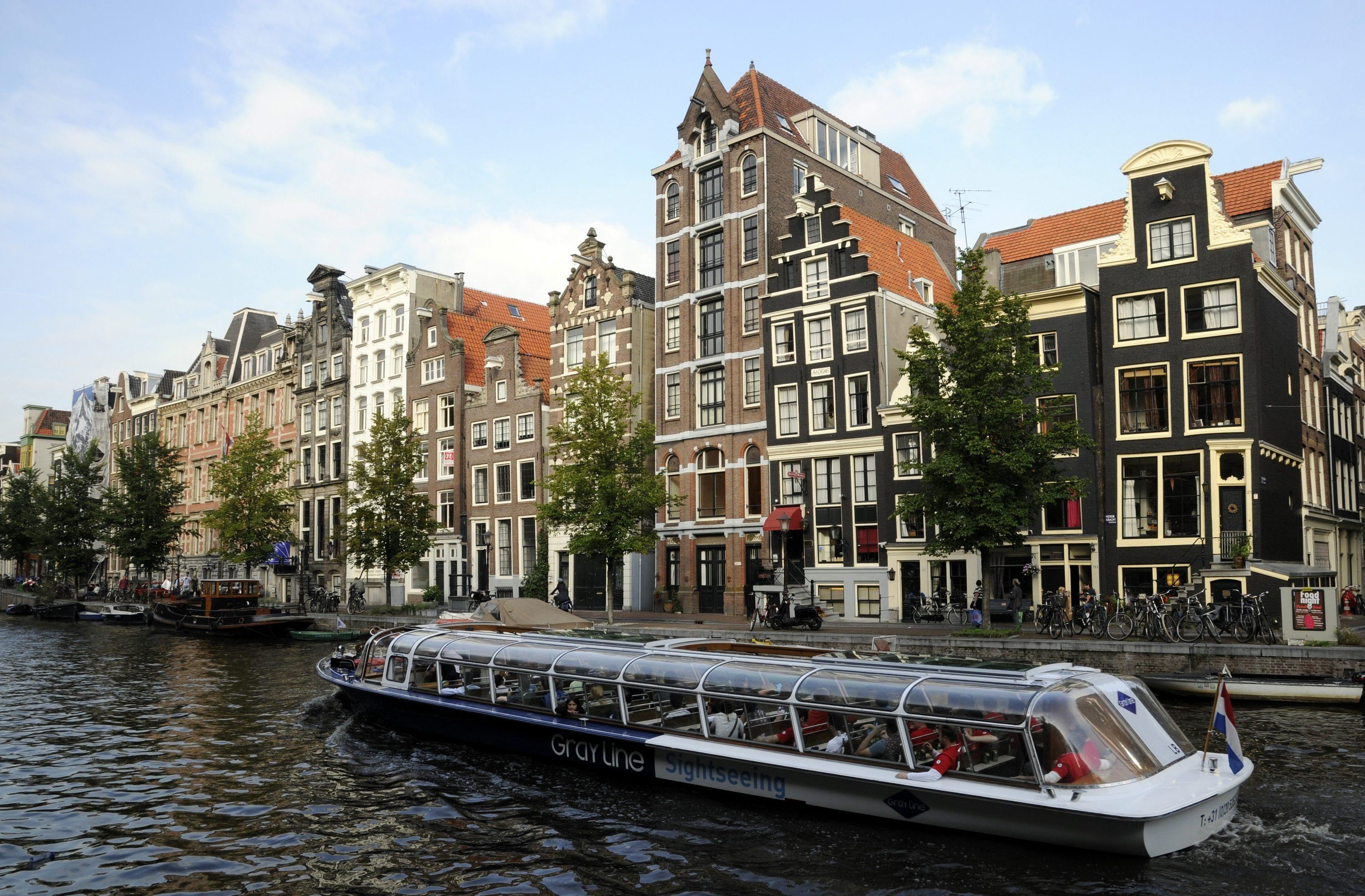 Die Giebelhäuser des Amsterdamer Grachtengürtels lassen sich angenehm mit dem Ausflugsboot besichtigen.