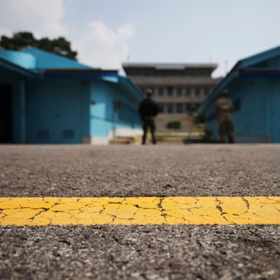 Blick auf die entmilitarisierte Zone, die die Nord- und Südkorea trennt. Hinter einer gelben Linie stehen zwei Soldaten in der Nähe des Grenzübergangs Panmumjon.