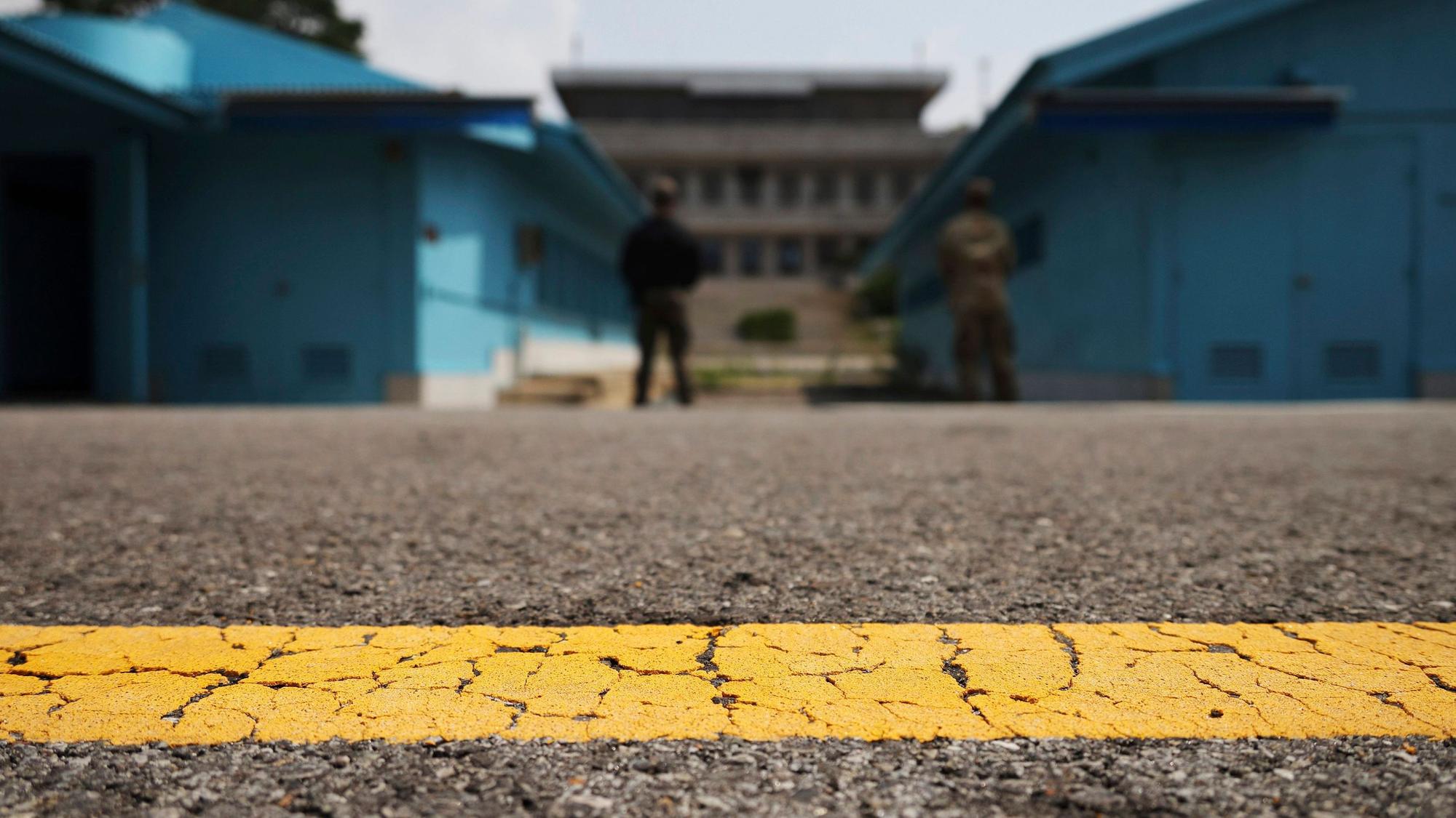Blick auf die entmilitarisierte Zone, die die Nord- und Südkorea trennt. Hinter einer gelben Linie stehen zwei Soldaten in der Nähe des Grenzübergangs Panmumjon.