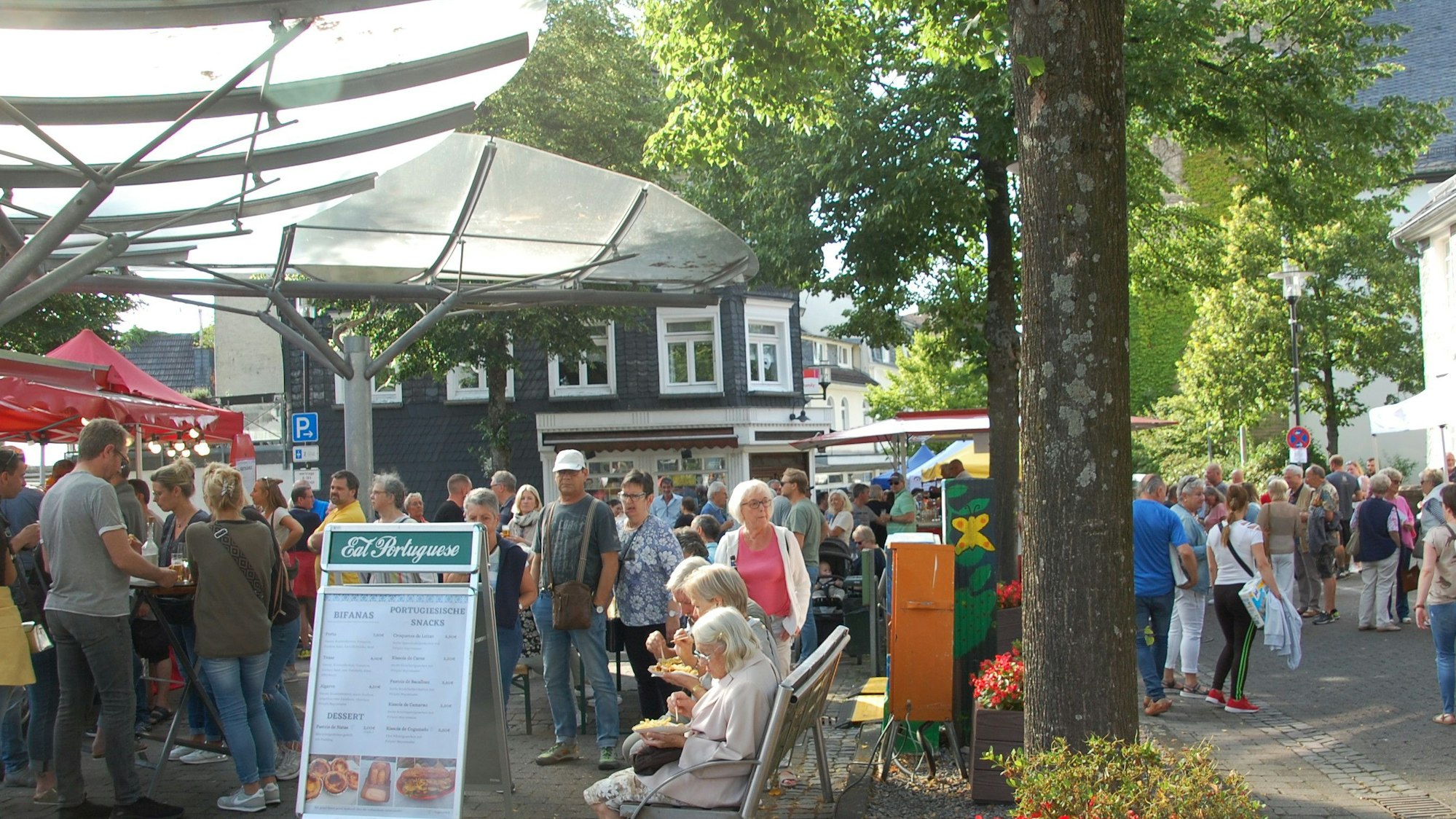 Menschen gehen an Marktständen in Burscheid vorbei.