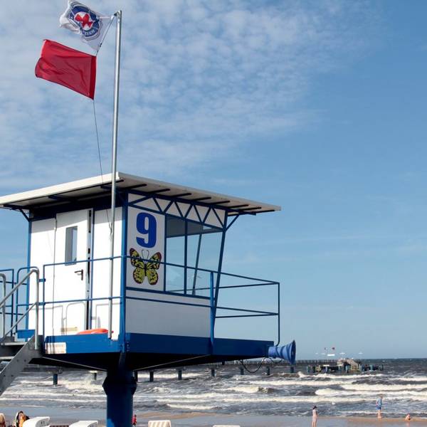 An einem Strand auf der Ostsee-Insel Usedom weht an einem Beobachtungsposten eine rote Fahne, die zeigt, dass Baden derzeit verboten ist.