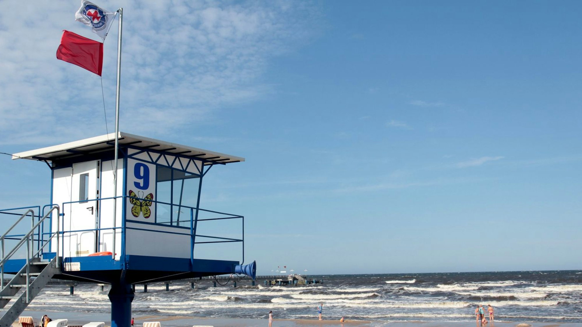 An einem Strand auf der Ostsee-Insel Usedom weht an einem Beobachtungsposten eine rote Fahne, die zeigt, dass Baden derzeit verboten ist.