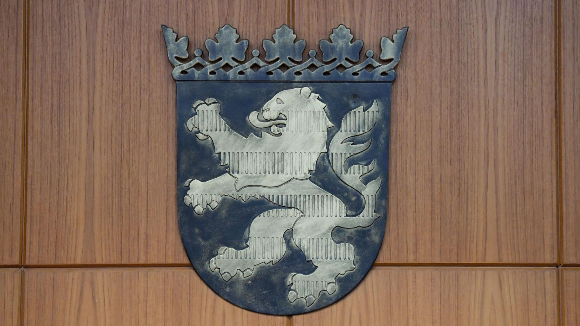Ein Wappen mit dem Hessen-Löwen ist in einem Gerichtssaal des Frankfurter Landgerichts an der Wand befestigt.