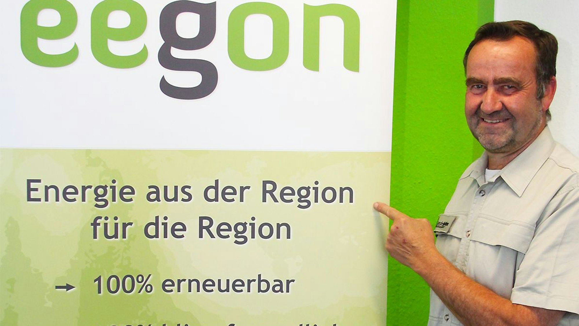 Ein Mann deutet auf ein Plakat.