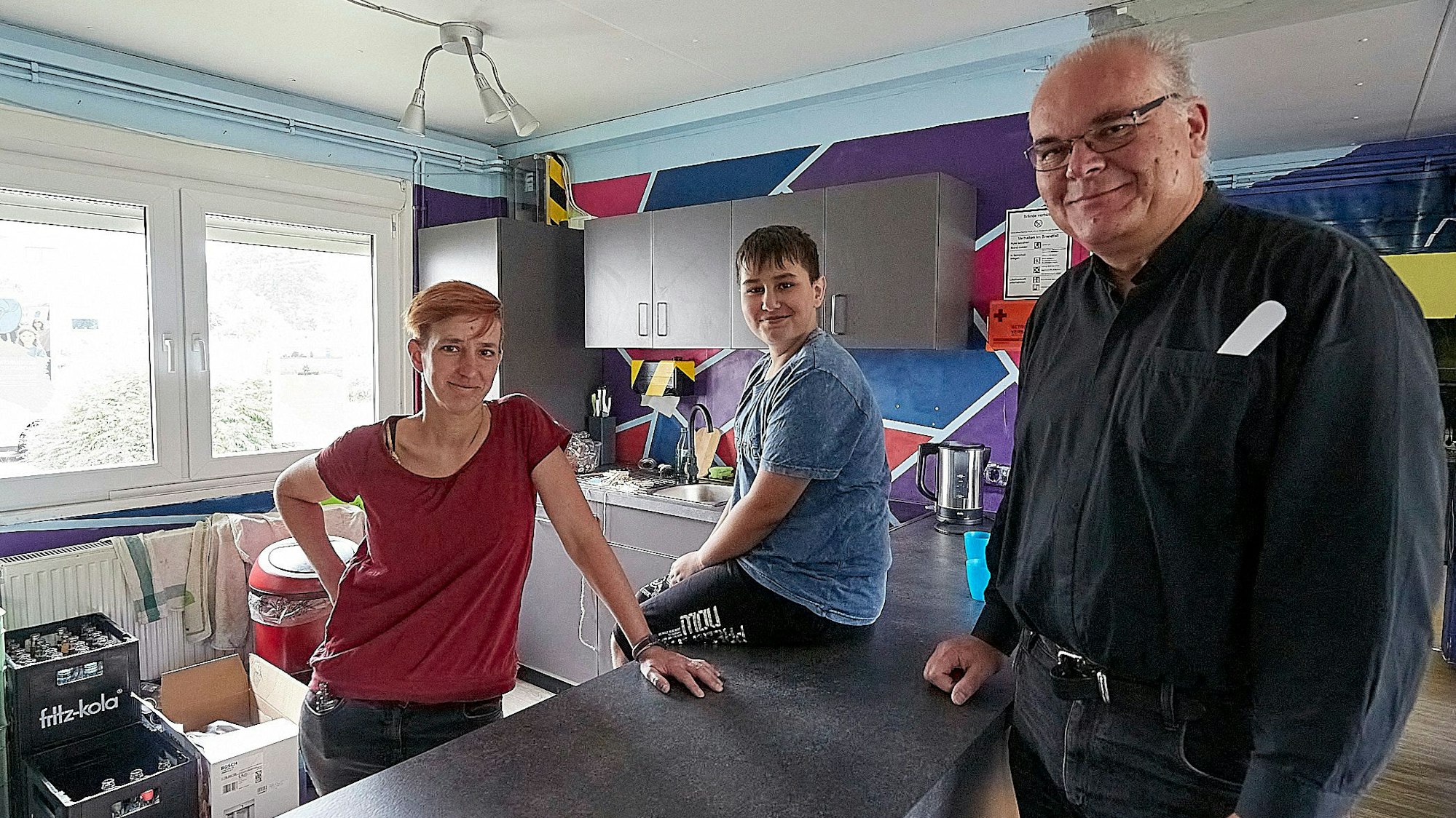 Drei Menschen sind in der neuen Küche, die in der Hellenthaler Jugendeinrichtung Point installiert wurde.