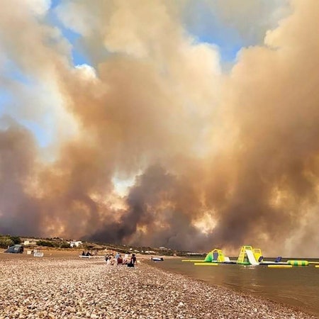 Dichte Rauchwolken eines Waldbrandes steigen auf der griechischen Insel Rhodos in den Himmel.