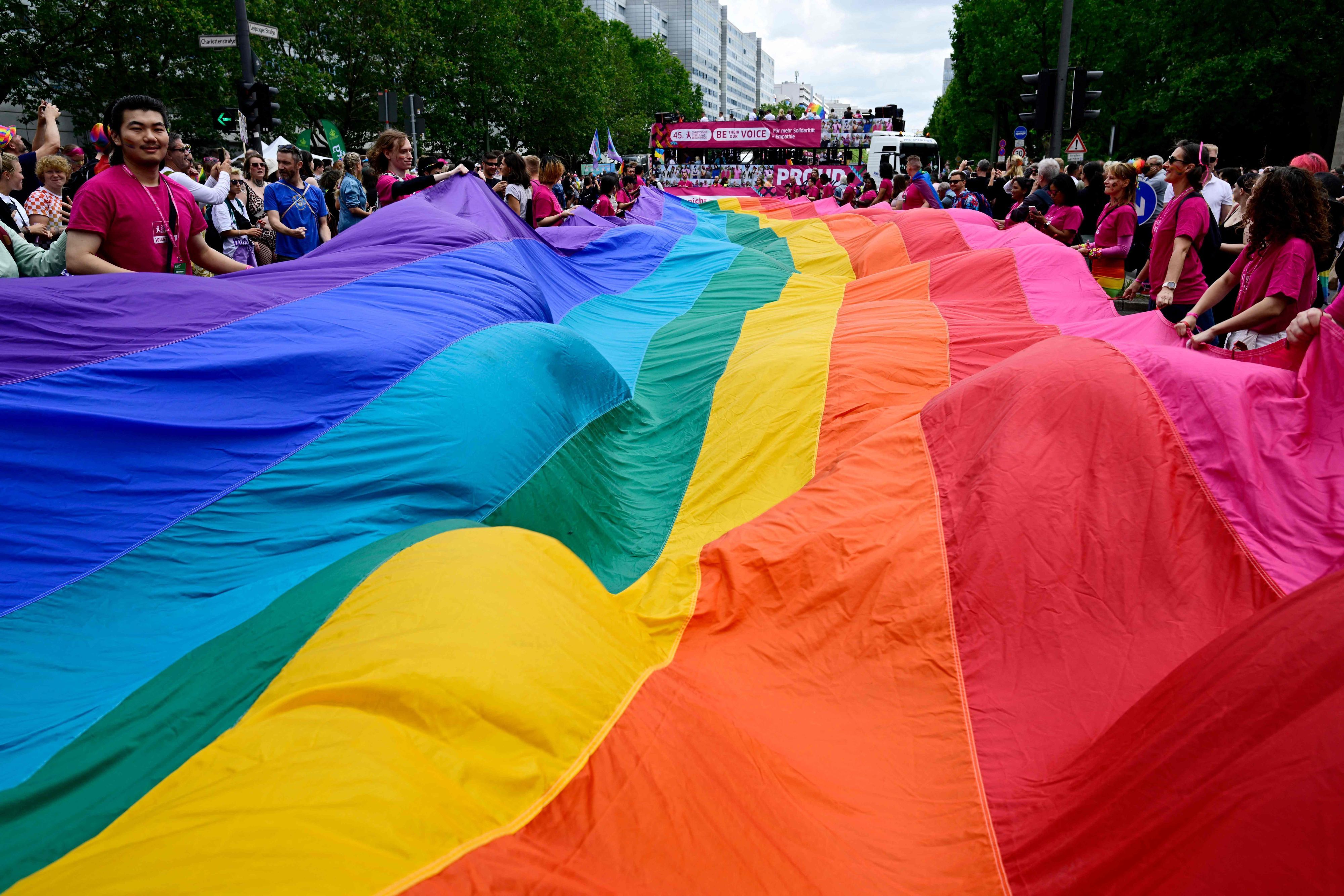 Participants carry a giant rainbow banner at the start of the convoi of the yearly Christopher Street Day (CSD) parade in Berlin on July 22, 2023. The 45th Christopher Street Day Parade takes place on July 22 under the motto 'Be their voice - and ours! ... for more empathy and solidarity'. (Photo by John MACDOUGALL / AFP)