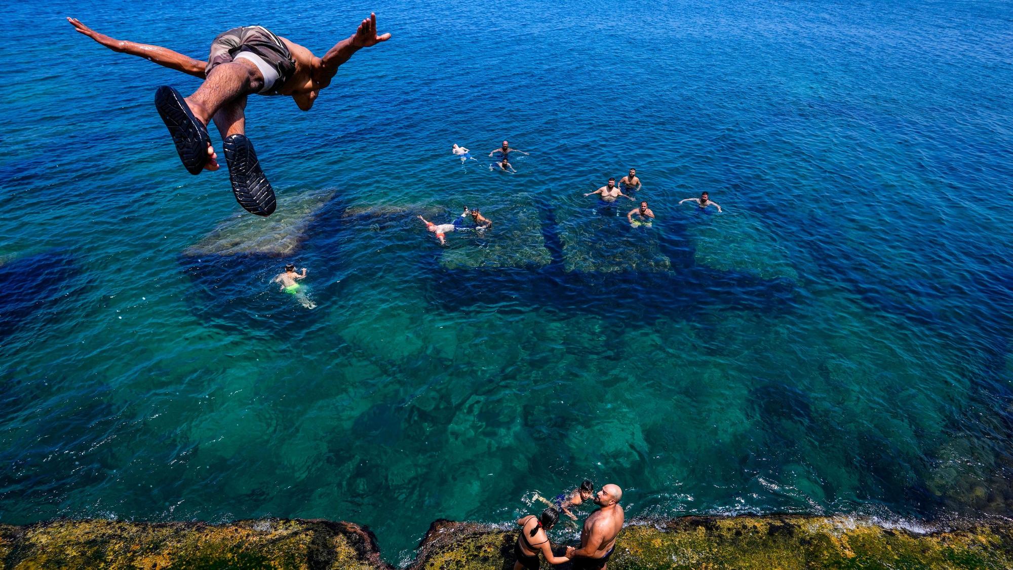Libanon, Beirut: Ein Jugendlicher springt ins Wasser, um sich an einem drückend heißen Tag im Mittelmeer abzukühlen.