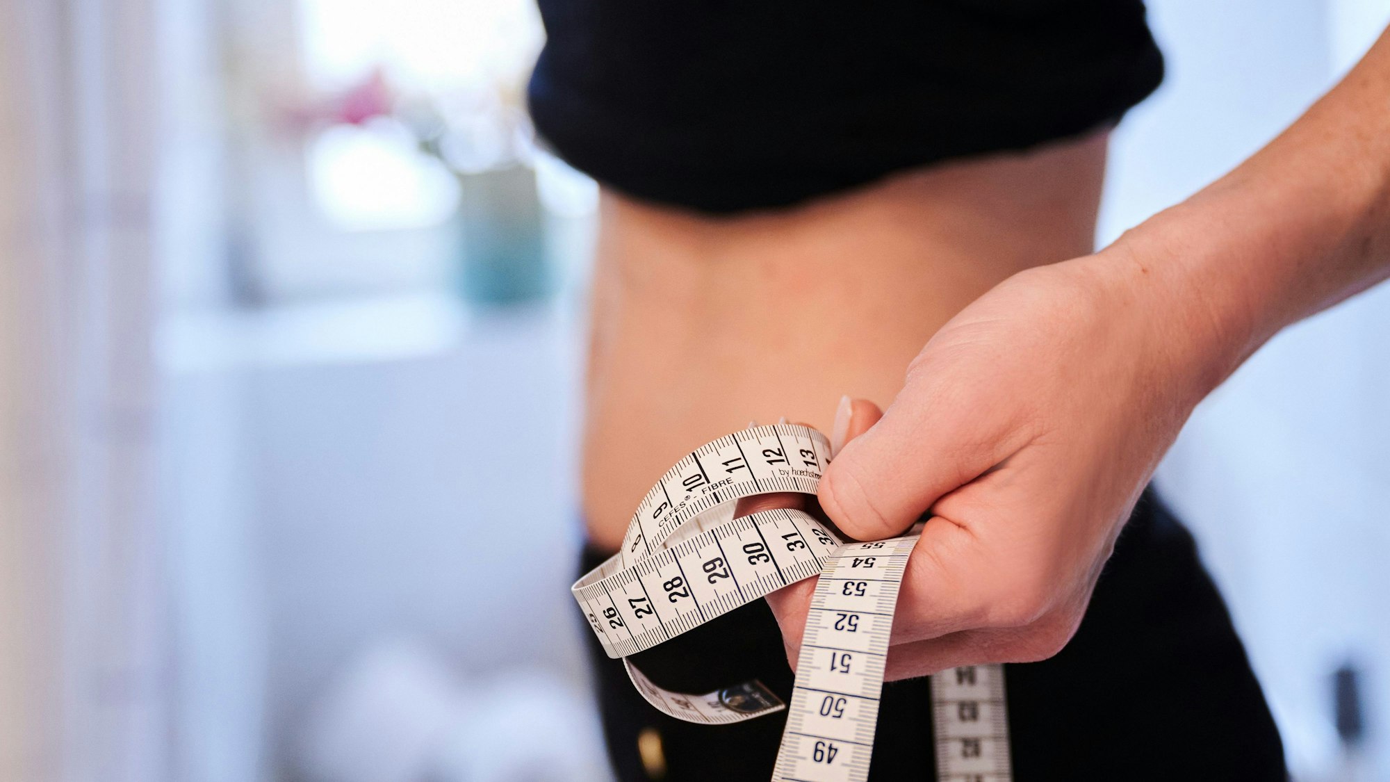 Das Symbolbild zeigt einen sehr dünnen Bauch und ein Maßband.