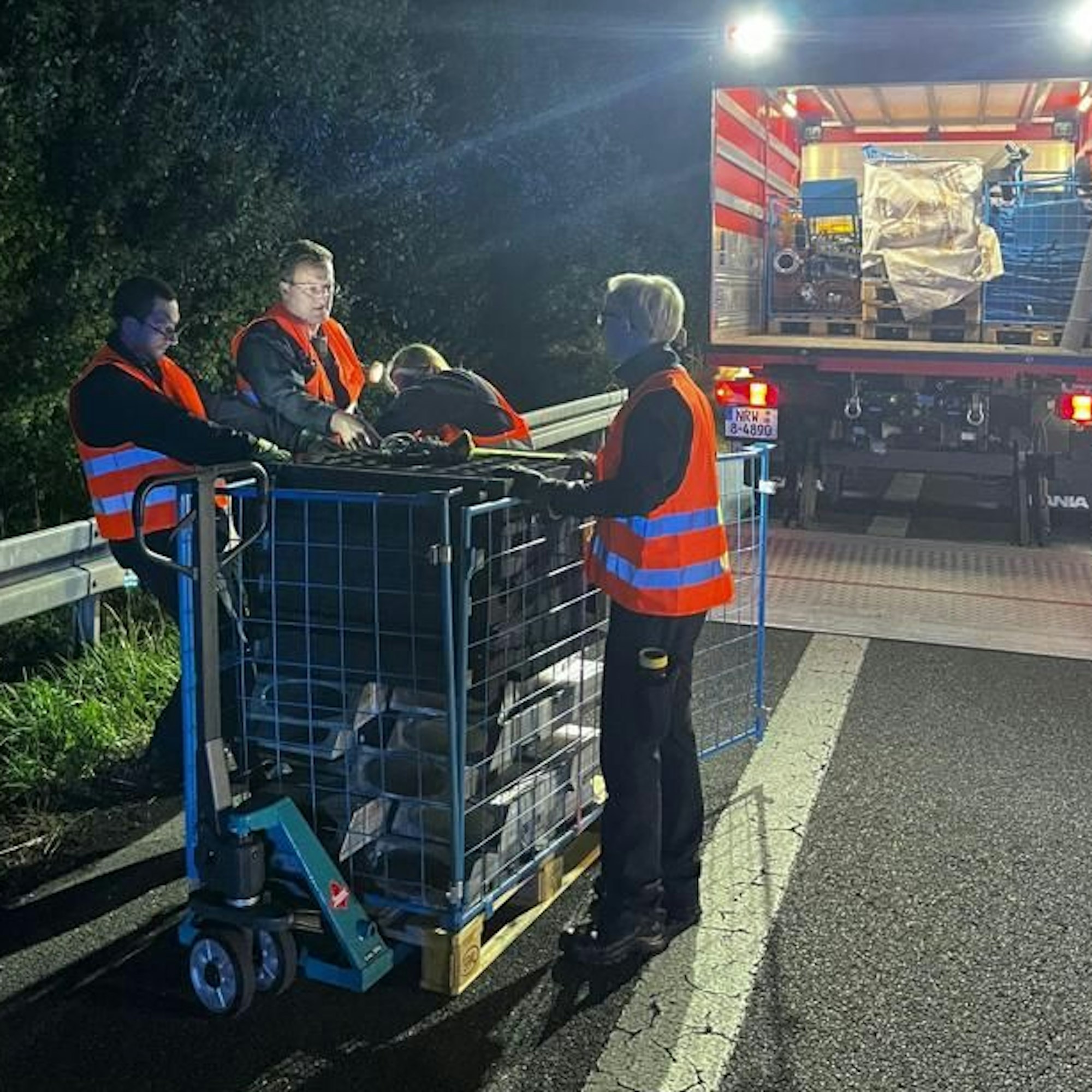 Feuerwehrleute laden einen Stahlgittercontainer aus einem Gerätewagen Logistik der Feuerwehr.