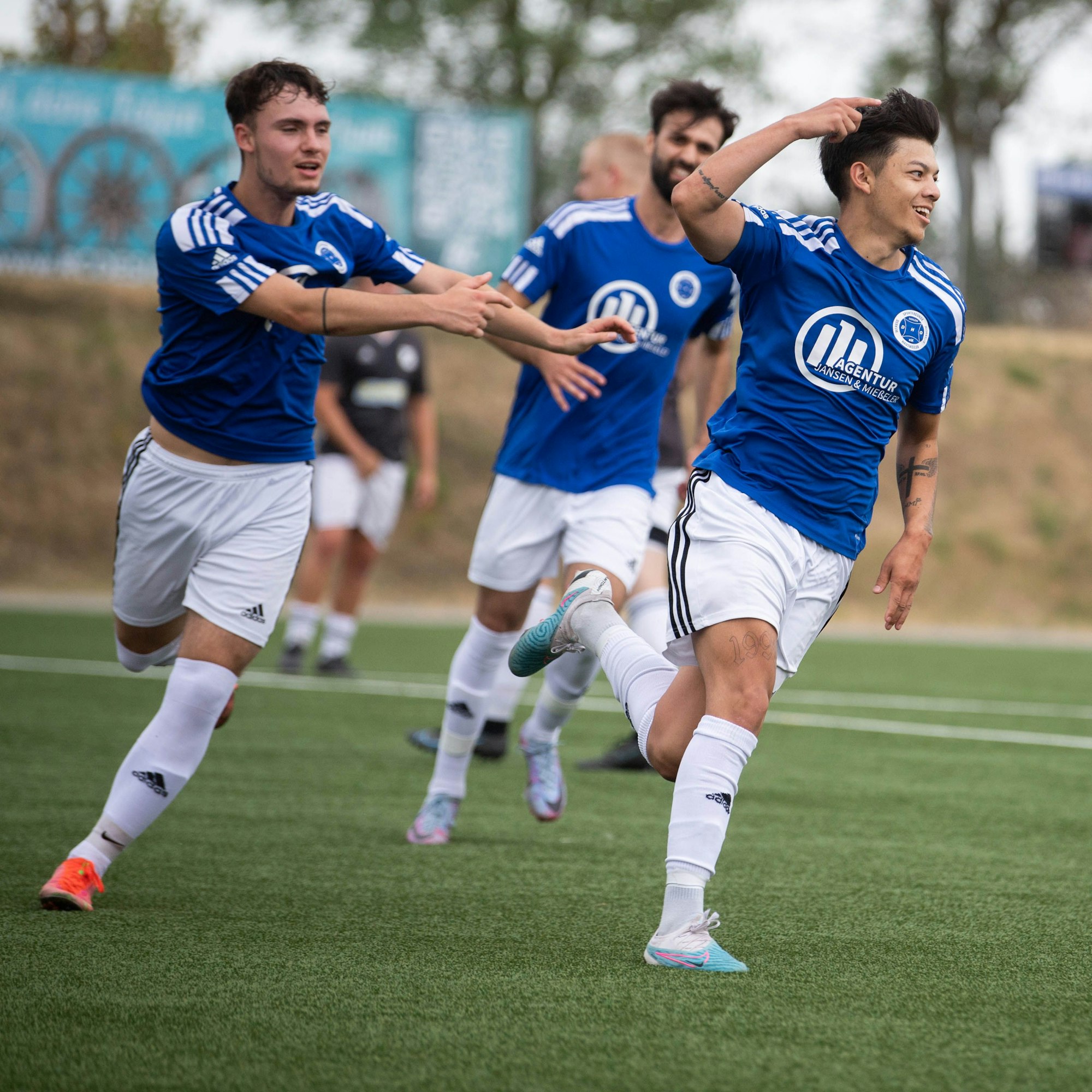 Alex Prüfer jubelt und wird von Mitspielern verfolgt, die sich mit ihm über den entscheidenden Treffer freuen.