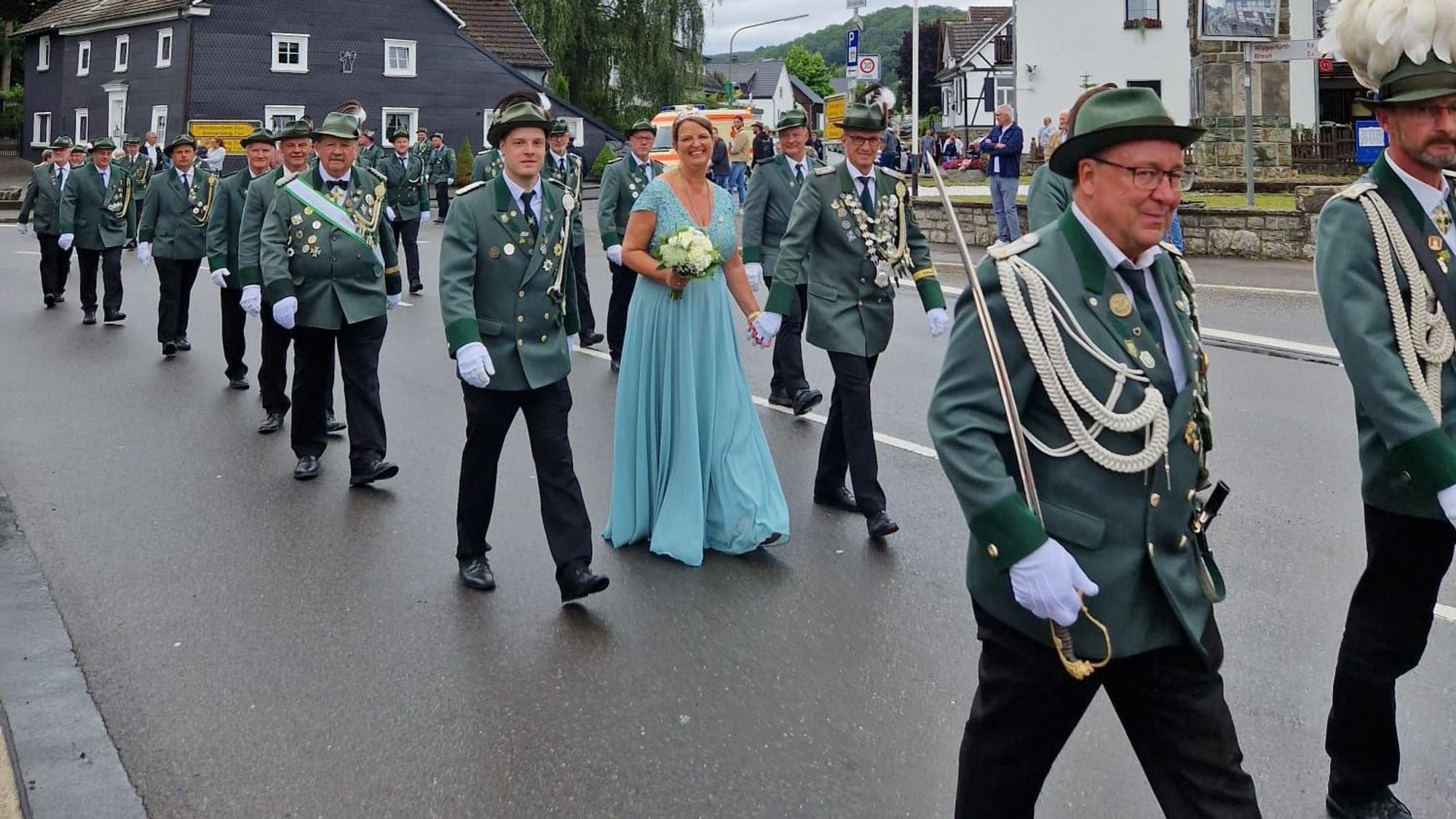 Schützen bei einem Festumzug auf einer Straße.