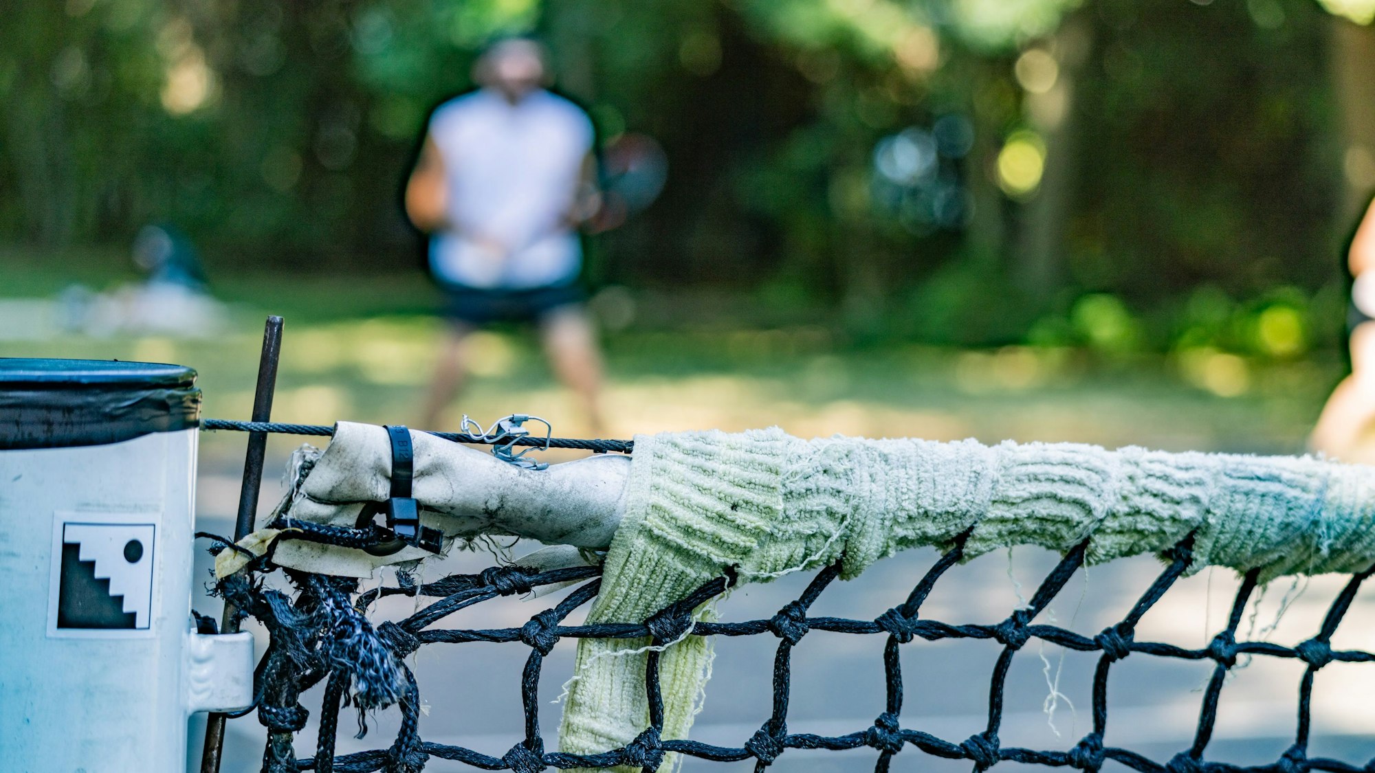 Ein geflicktes Netz auf dem Tennisplatz im Grüngürtel