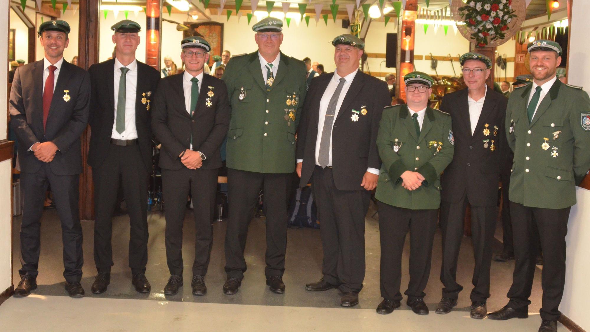Mehrere Schützenbrüder stehen in Uniform und mit Orden nebeneinander.