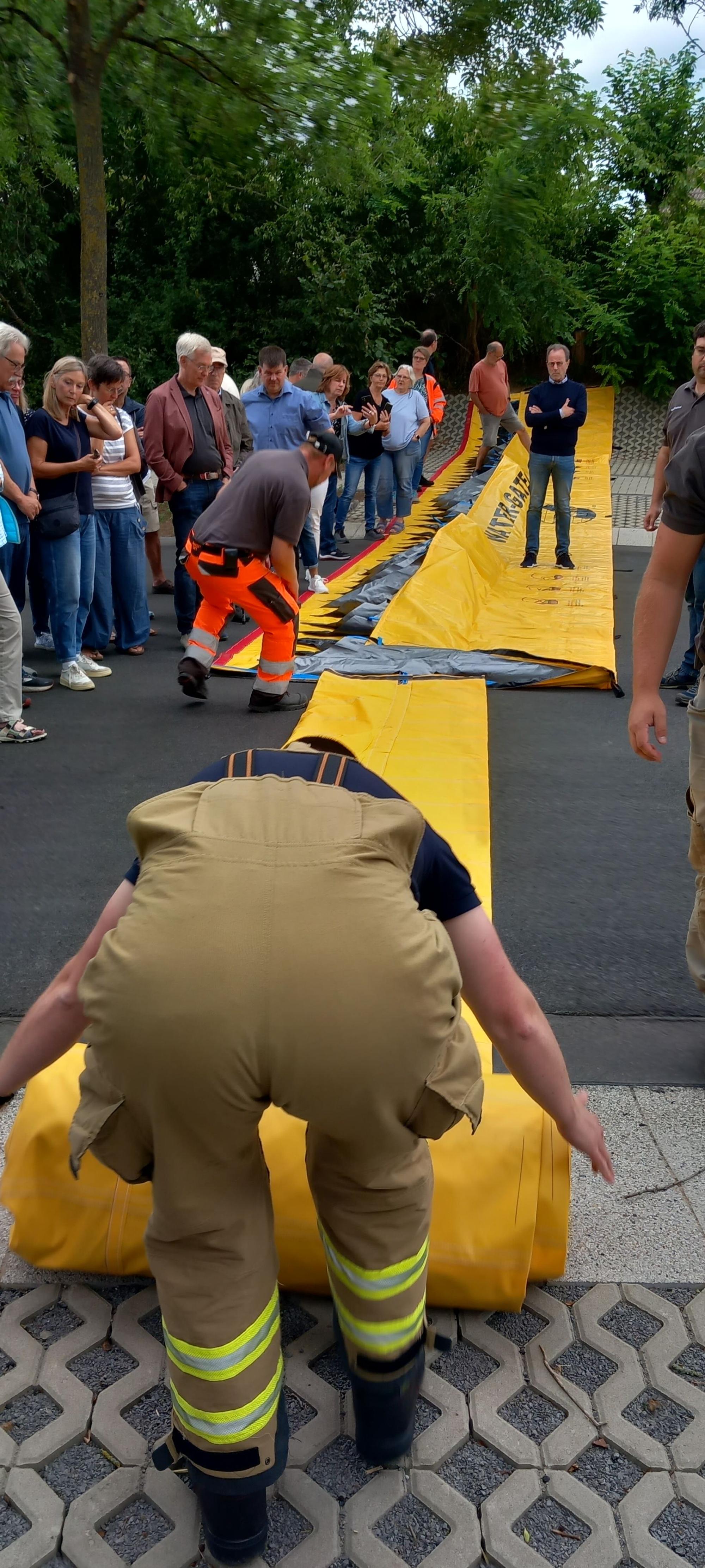 24.7.2023 Helfer rollen die Hochwasserbarriere für das Rodderfeld in Rheinbach aus
