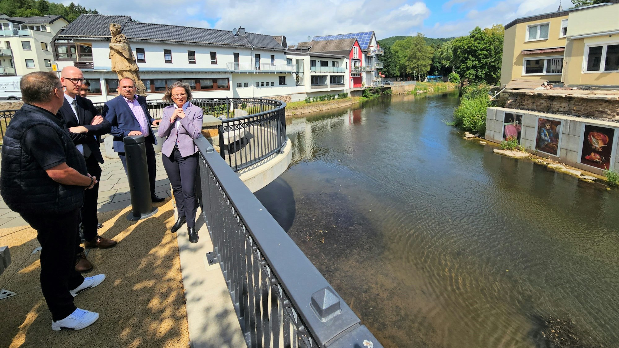 Mehrere Männer und eine Frau stehen am Zusammenfluss von Urft und Olef in Gemünd.