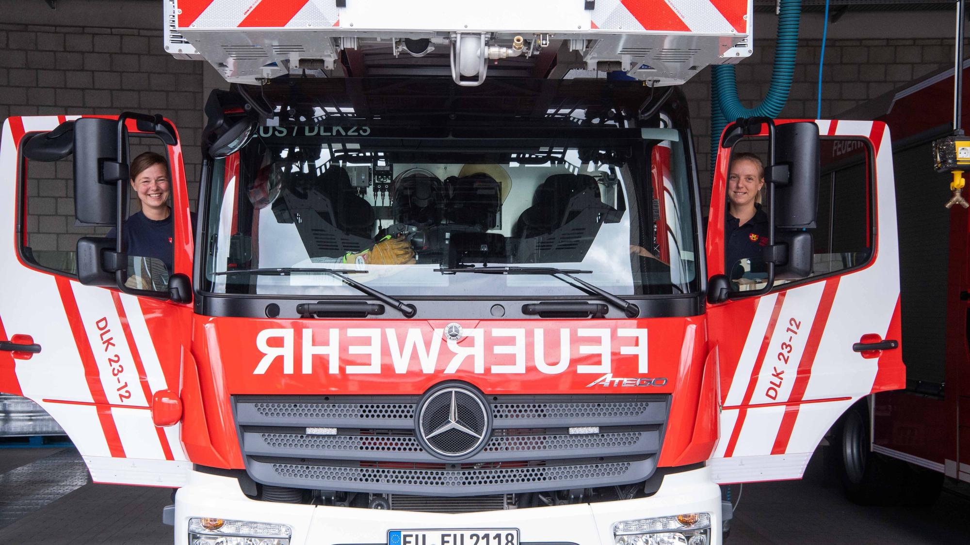 Zwei Feuerwehrfrauen steigen in die Drehleiter der Euskirchener Feuerwehr ein.