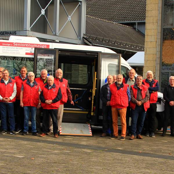 Fahrerinnen und Fahrer des Bürgerbusvereins Kürten stehen vor ihrem Bus.