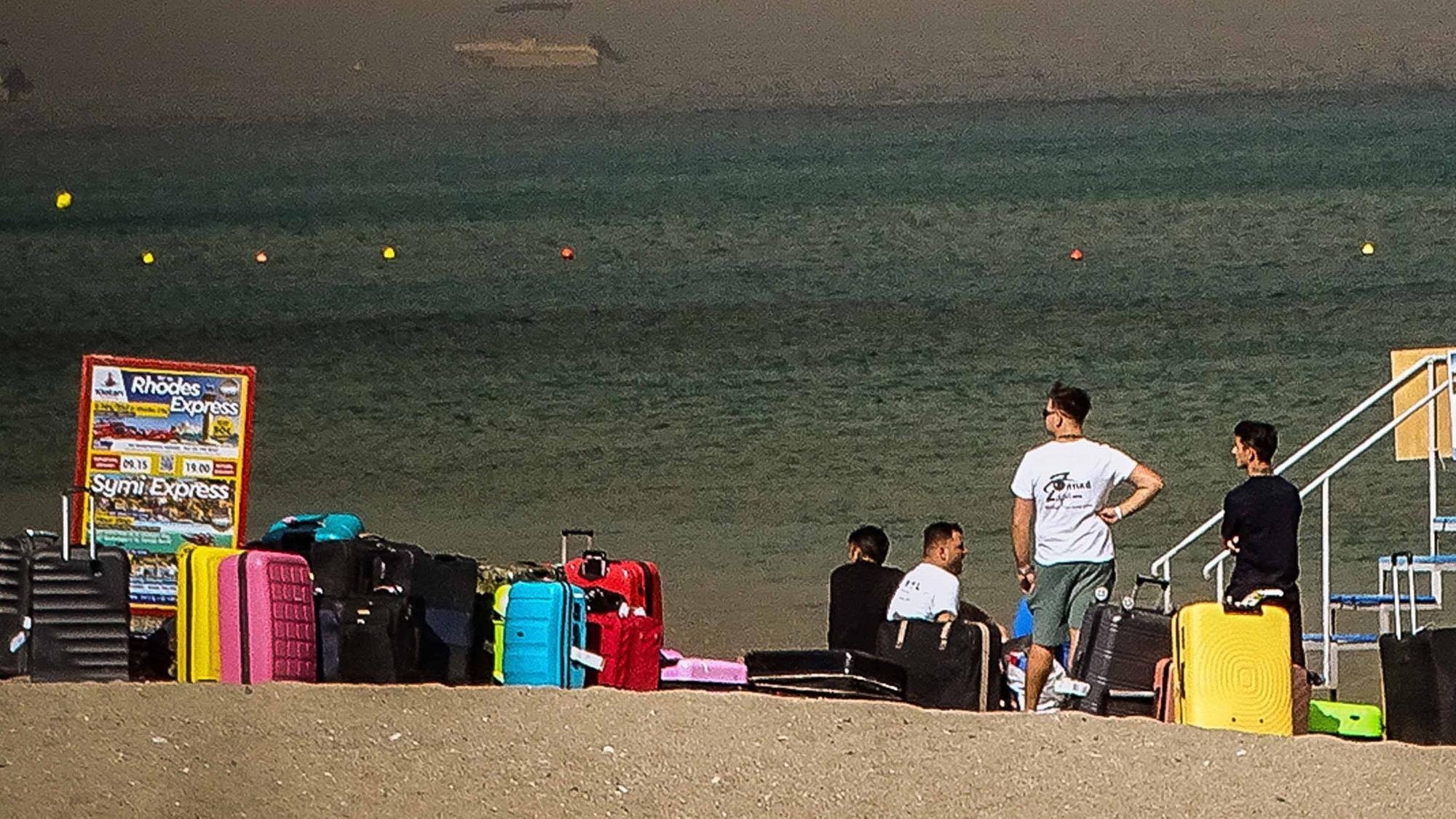 Menschen warten auf der griechischen Insel Rhodos darauf, vor den katastrophalen Waldbränden in Sicherheit gebracht zu werden.