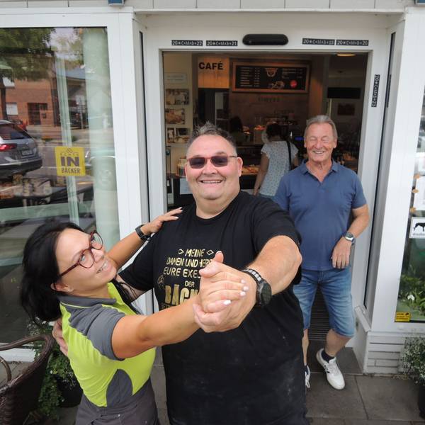 Guido Boveleth und seine Mitarbeiterin Sarah Porwol demonstrieren vor der Bäckereifiliale in Kaster, wie es geht: Wer tanzt, bekommt Brötchen oder Teilchen.