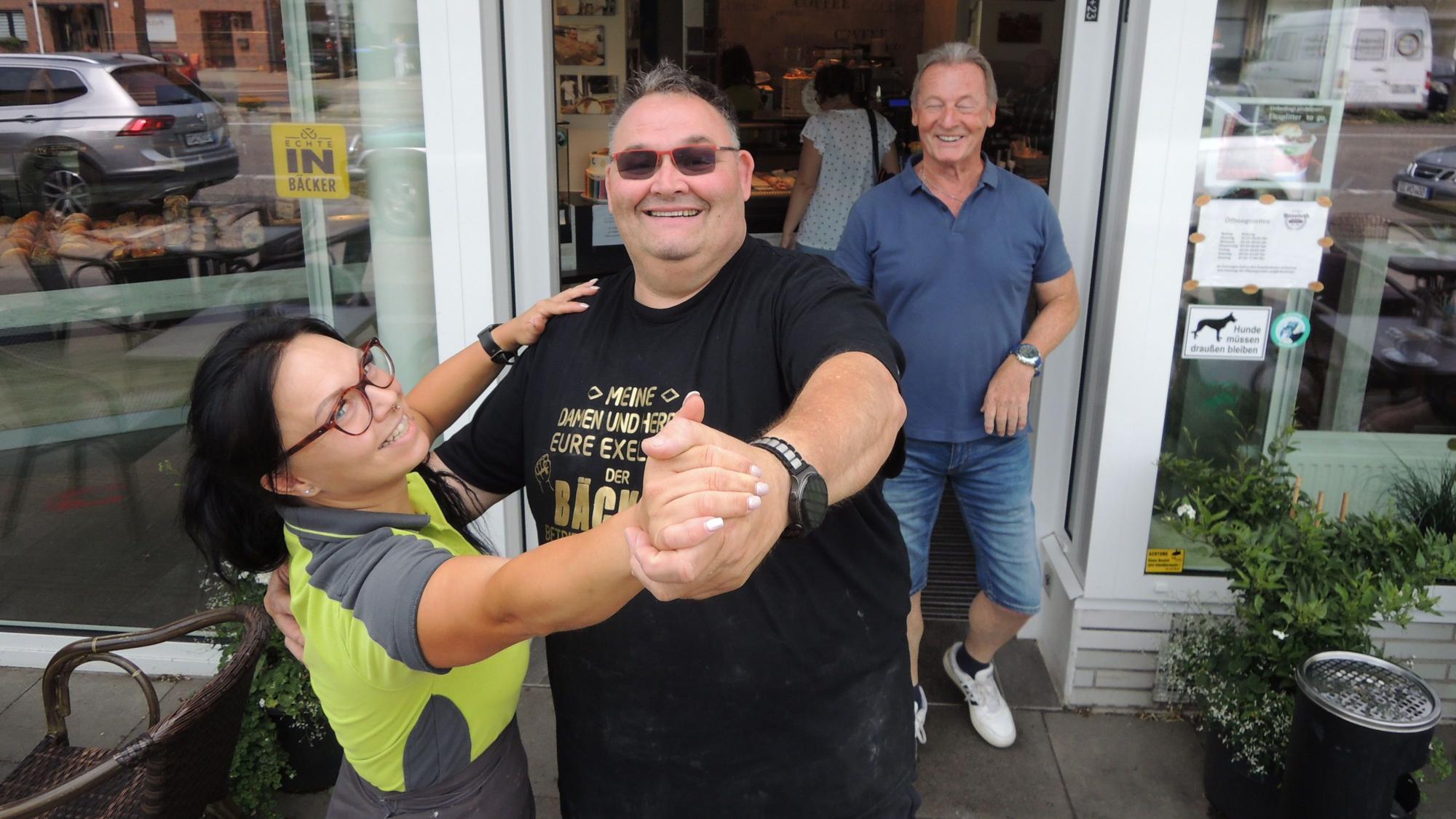 Guido Boveleth und seine Mitarbeiterin Sarah Porwol demonstrieren vor der Bäckereifiliale in Kaster, wie es geht: Wer tanzt, bekommt Brötchen oder Teilchen.