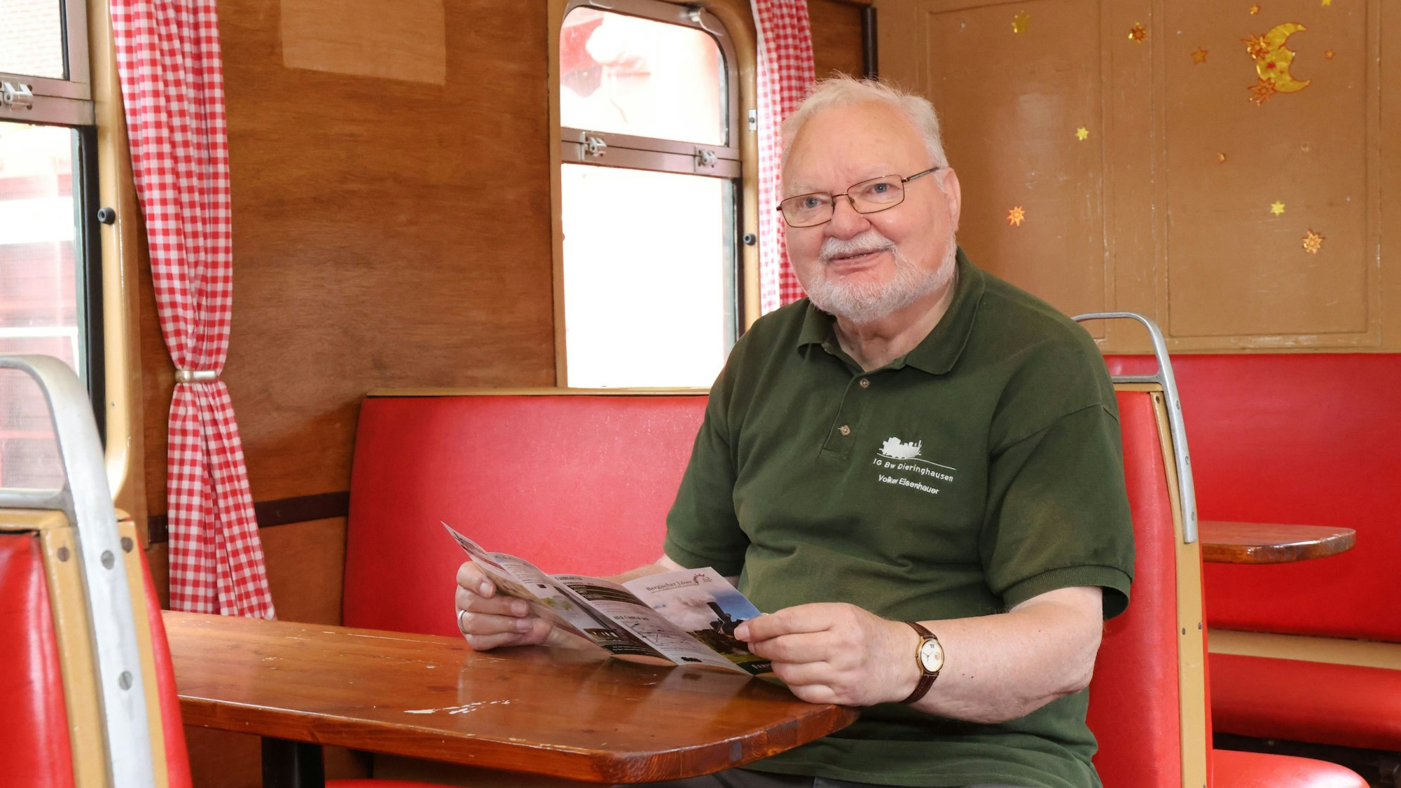 Volker Eisenhauer sitzt an einem Tisch in einem alten Eisenwagenwagon.