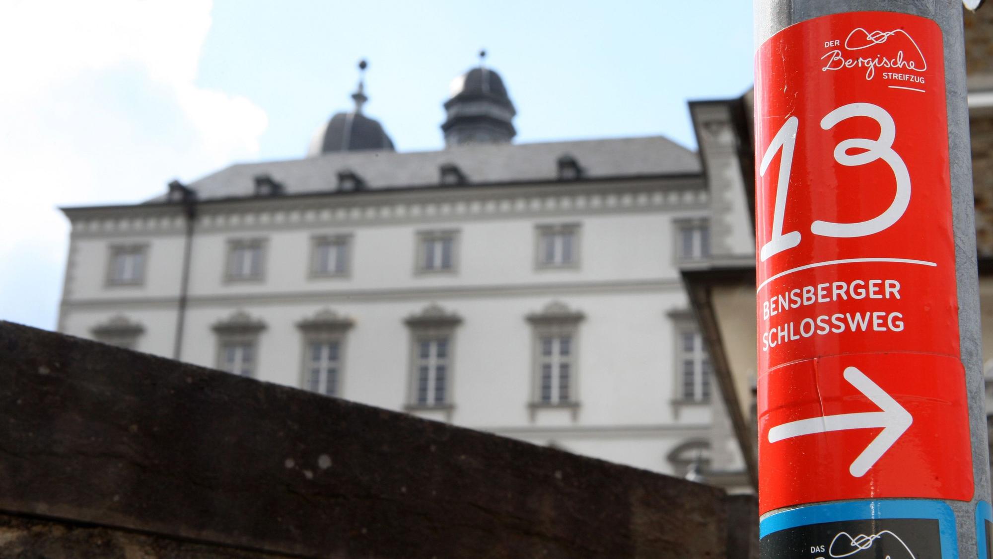 Die Wegemarkierung des Bensberger Schlosswegs klebt an einem Laternenpfahl vor dem Bensberger Barockschloss.