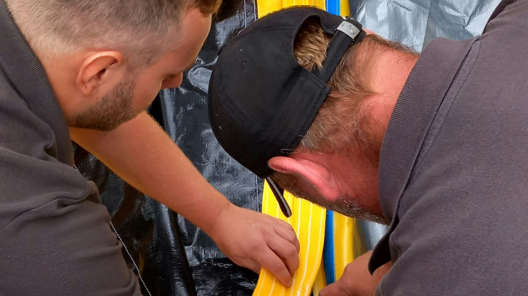 24.7.2023 Helfer verbinden die Hochwasserbarriere für das Rodderfeld in Rheinbach mit Klettbändern