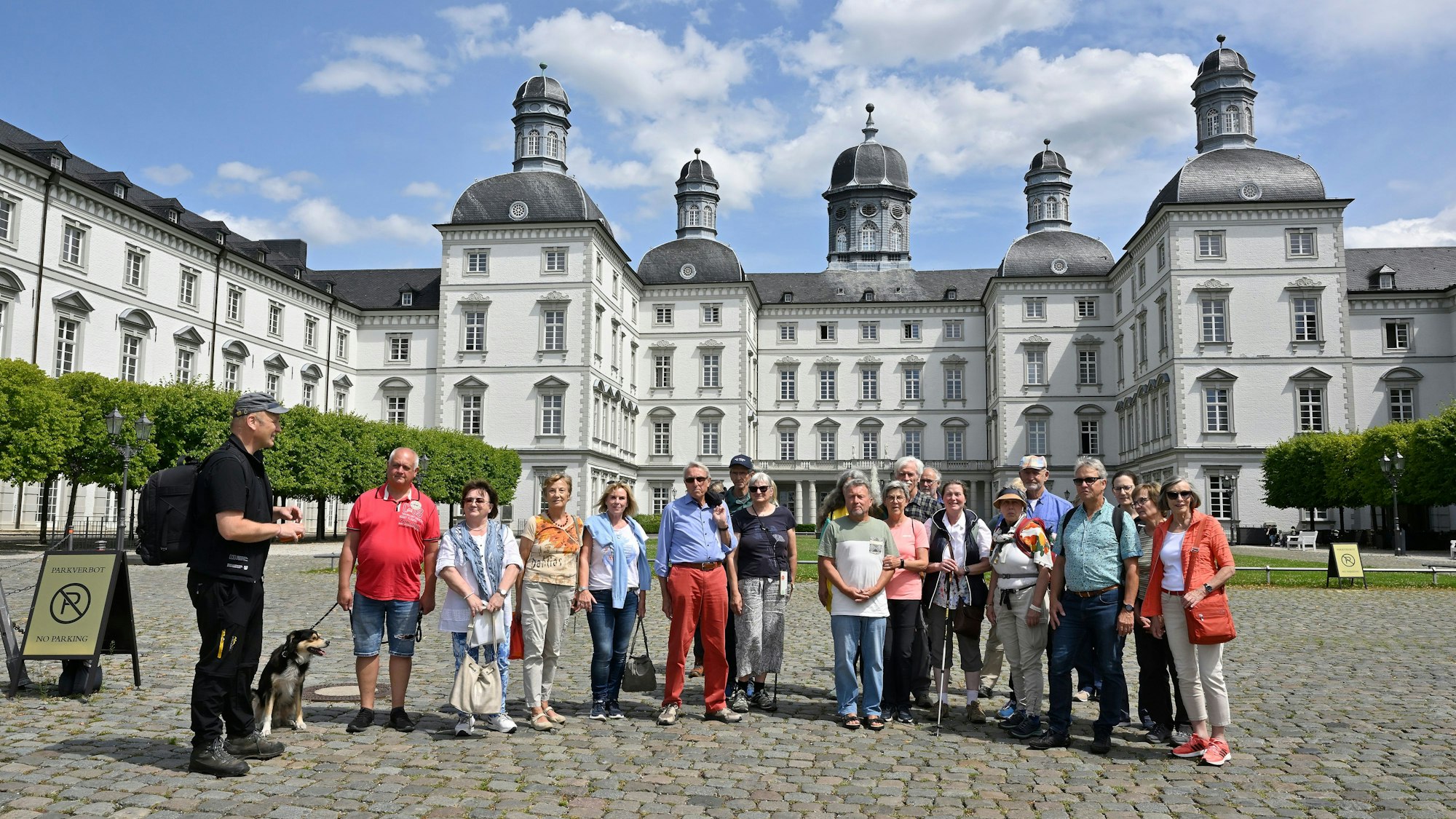 Eine Wandergruppe steht mit Naturparkführer und Redaktionsleiter Guido Wagner im Hof von Schloss Bensberg.