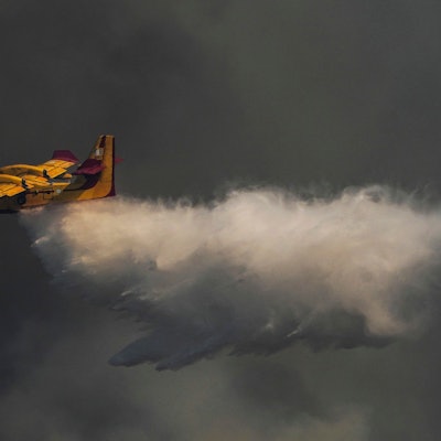 Hinter dem gelben Flugzeug sind dunkle Rauchwolke.