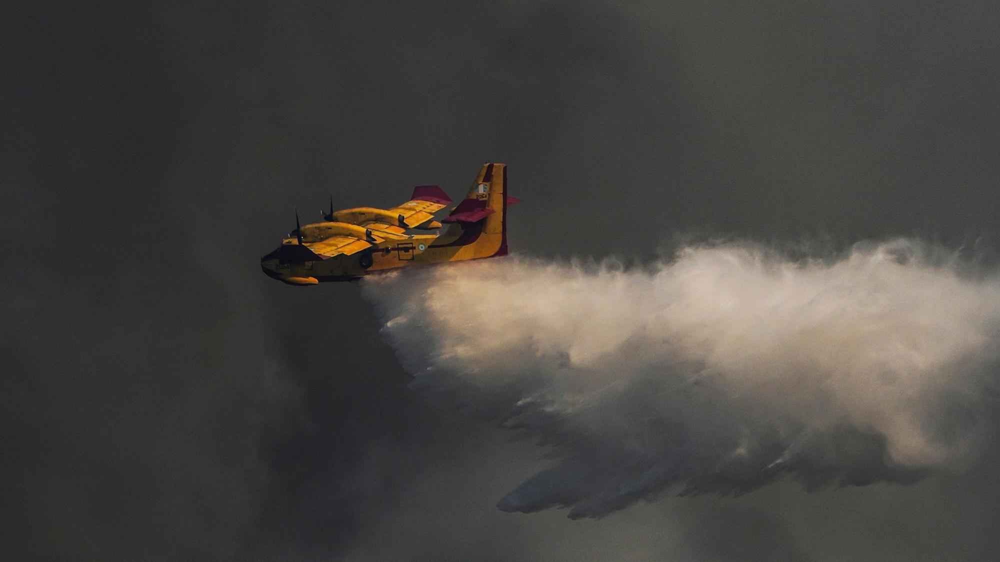 Hinter dem gelben Flugzeug sind dunkle Rauchwolke.