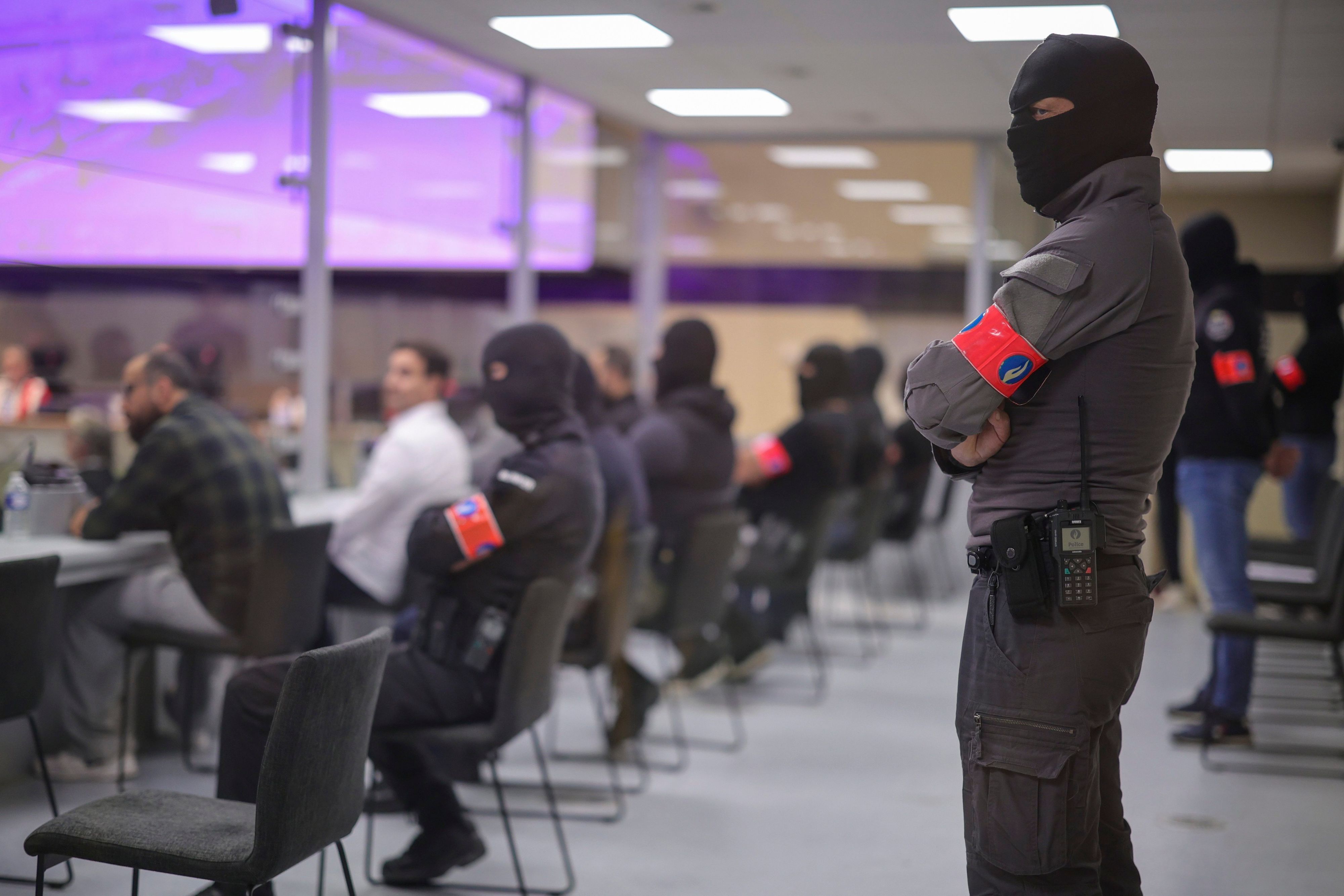 Prozess in Brüssel nach Terroranschlägen: Einige Angeklagte sitzen in einem extra entworfenen Glaskasten, Wachleute und Polizisten haben sich vermummt.