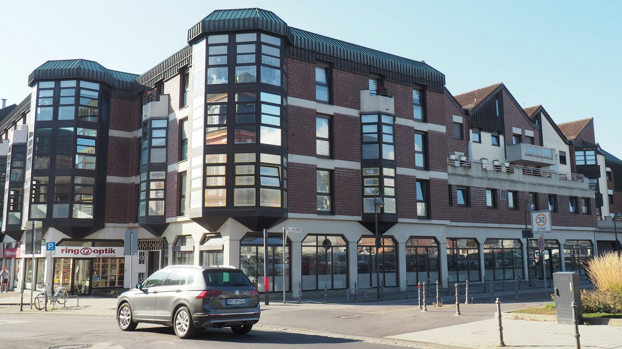 Ein Gebäude mit einer verklinkerten Fassade, die viele Glaselemente enthählt.