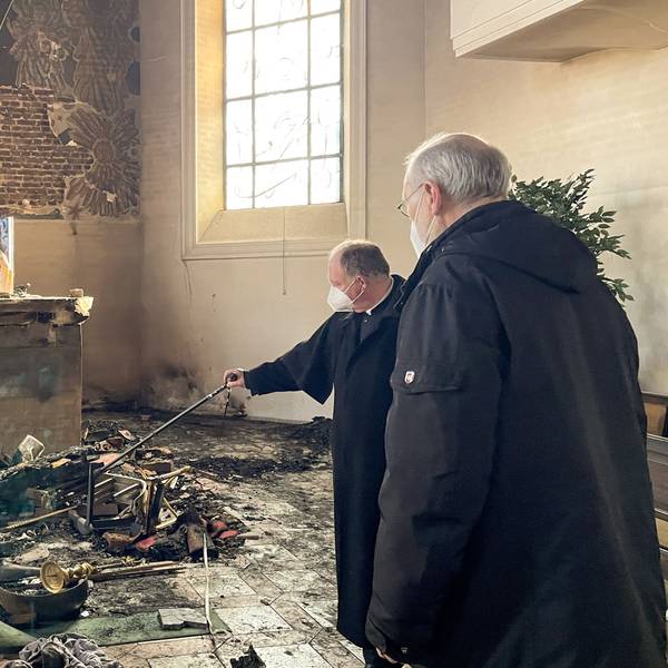 Weihbischof Ansgar Puff (r.) und Dechant Martin Kürten stehen in der zerstörten Pfarrkirche Kreuzerhöhung und betrachten das Ausmaß der Schäden. Für den Brand im Februar vergangenen Jahres muss sich jetzt ein Reichshofer vor dem Landgericht in Koblenz verantworten.