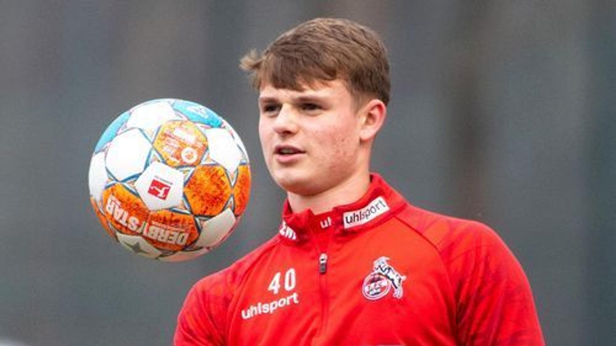 Das Bild zeigt Jonas Urbig während des Trainings beim 1. FC Köln. Er wird ein Ball hoch.