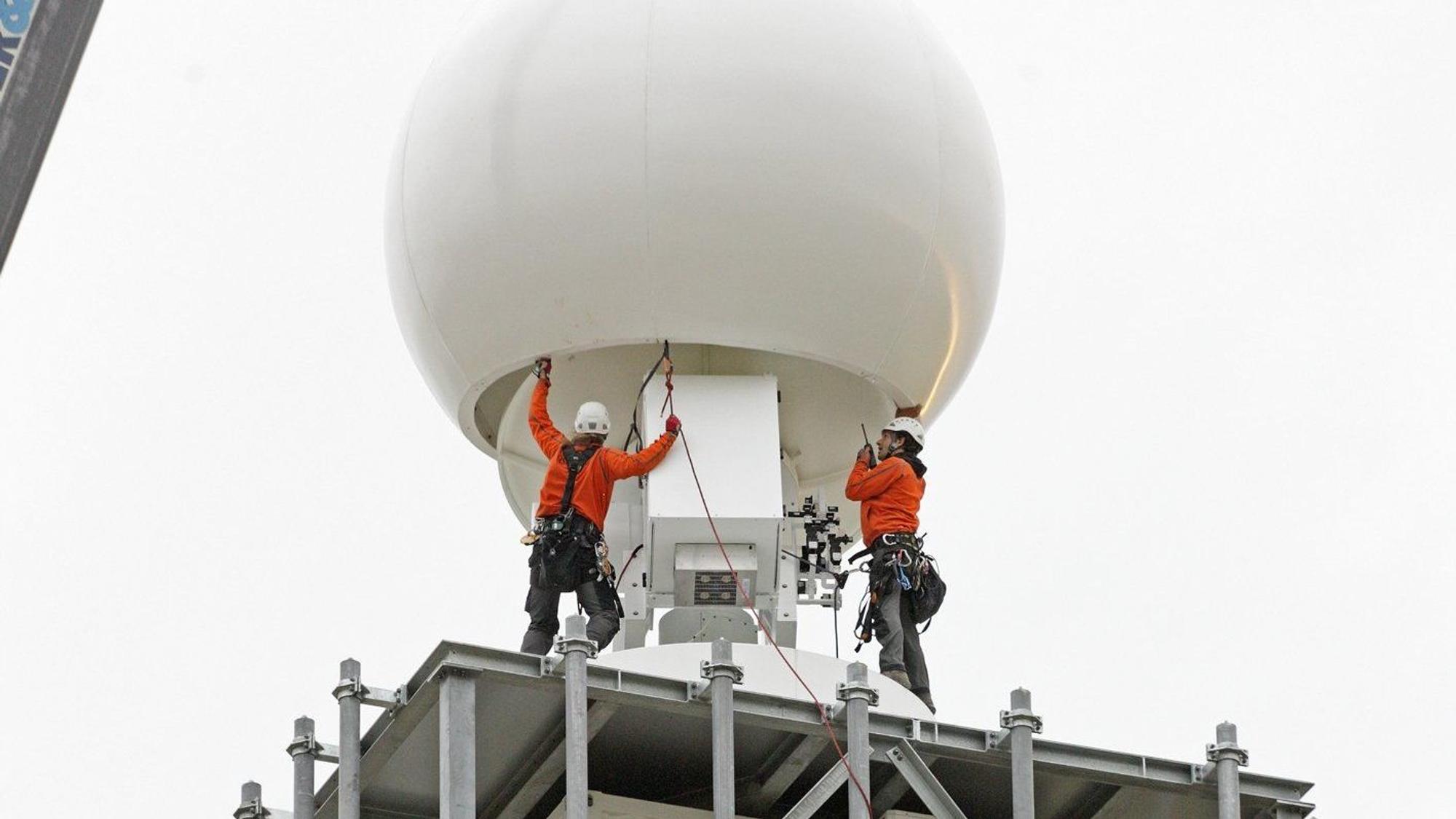 Arbeiter montieren auf einem Gelände in Jülich an einem Wetterradar (undatiertes Handout).