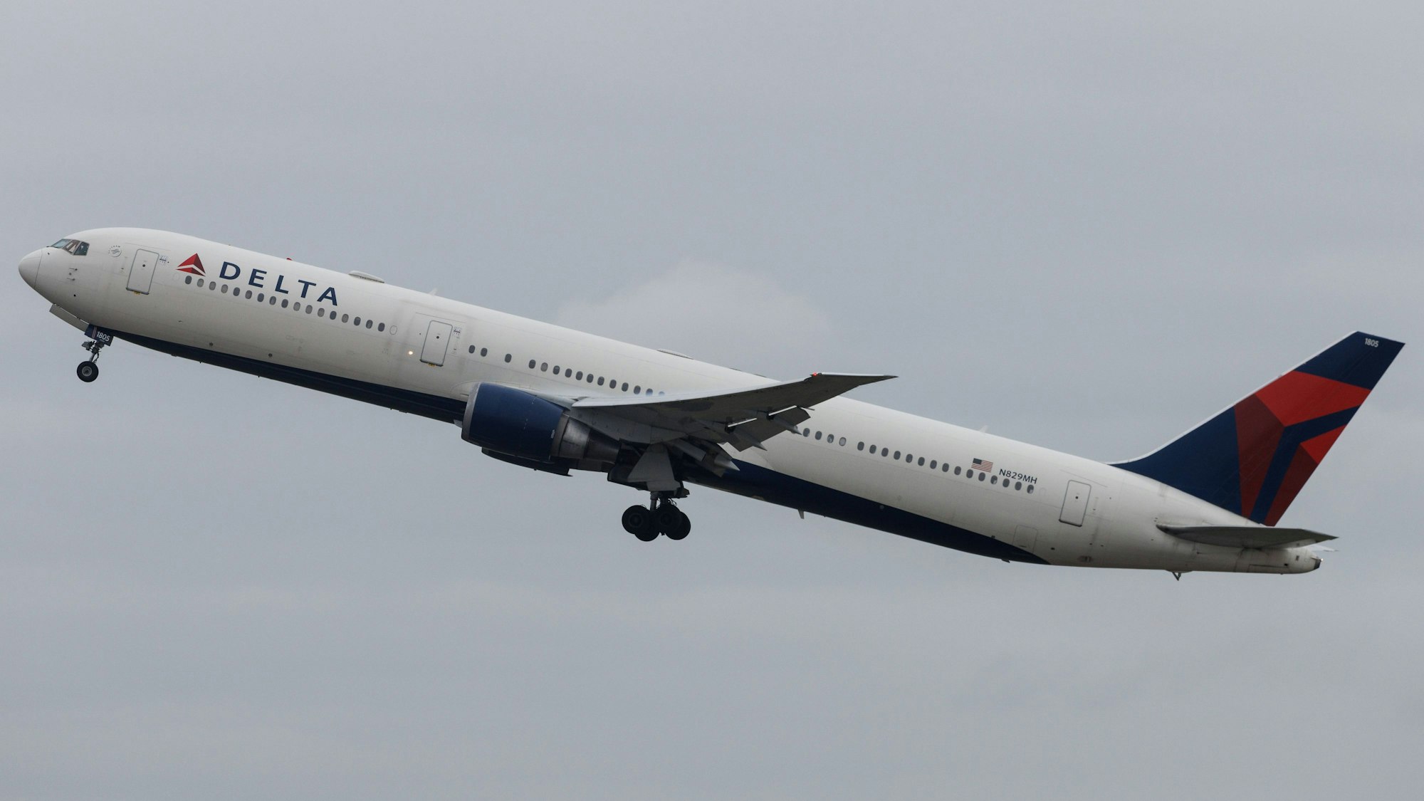 Eine Boeing 767 der US-amerikanischen Fluggesellschaft Delta Airlines startet in die Luft. Im Hintergrund kündigt sich ein Unwetter an. (Symbolbild)