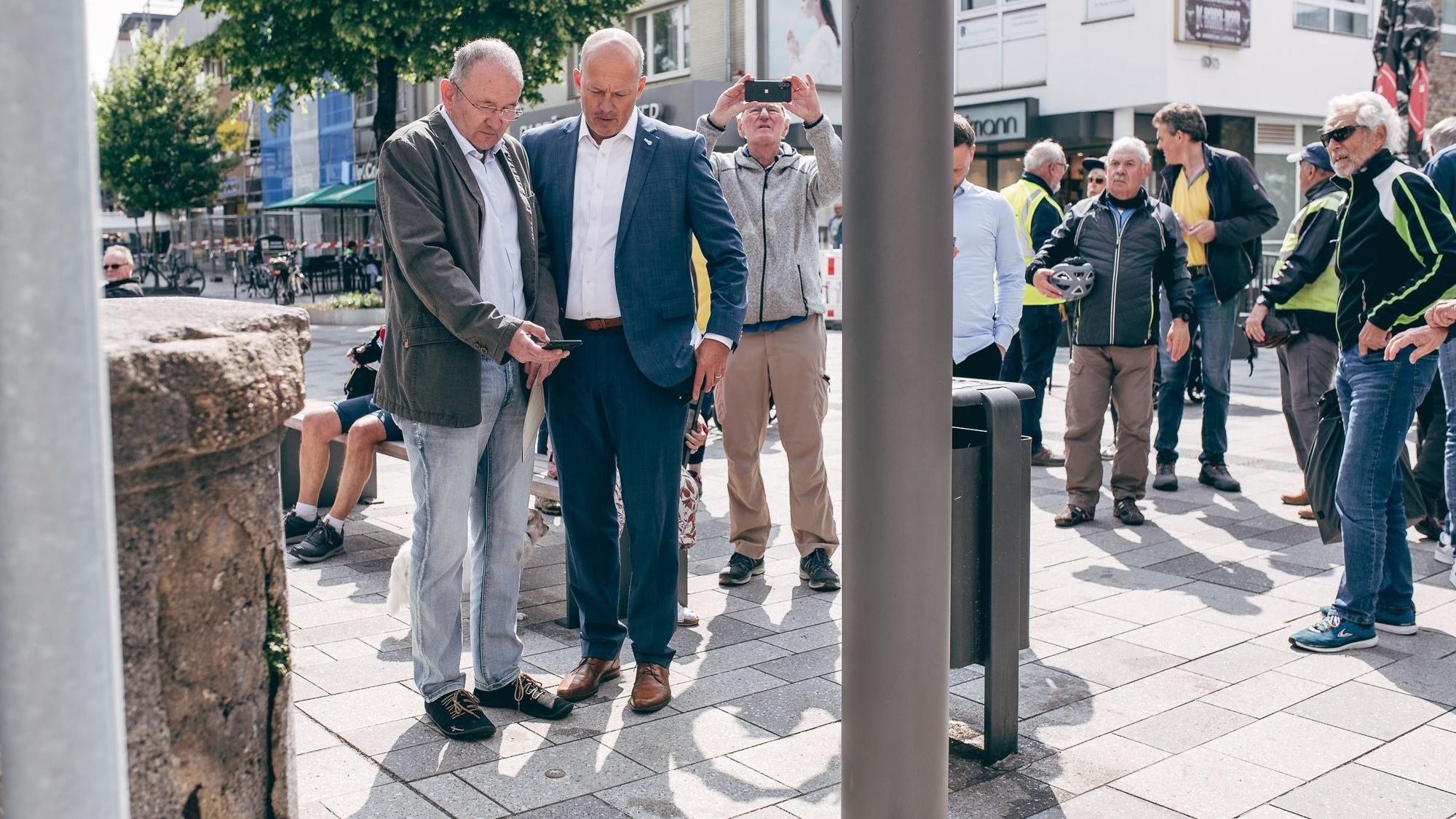 Das Bild zeigt mehrere Menschen, darunter Landrat Frank Rock, die um den GPS-Punkt stehen.